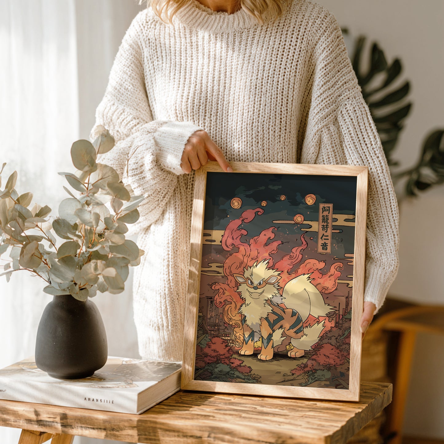 Person holding a framed artwork of Arcanine Pokemon in a home setting