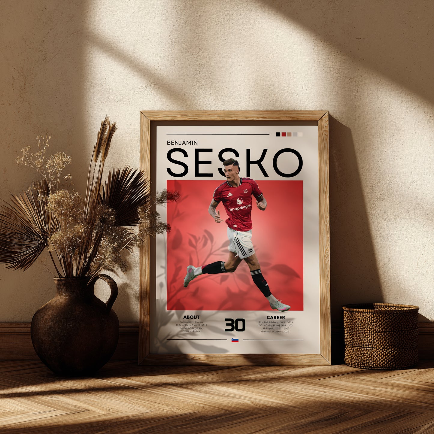 Framed poster of a soccer player with 'Sesko' on a red background, placed on a wooden shelf.