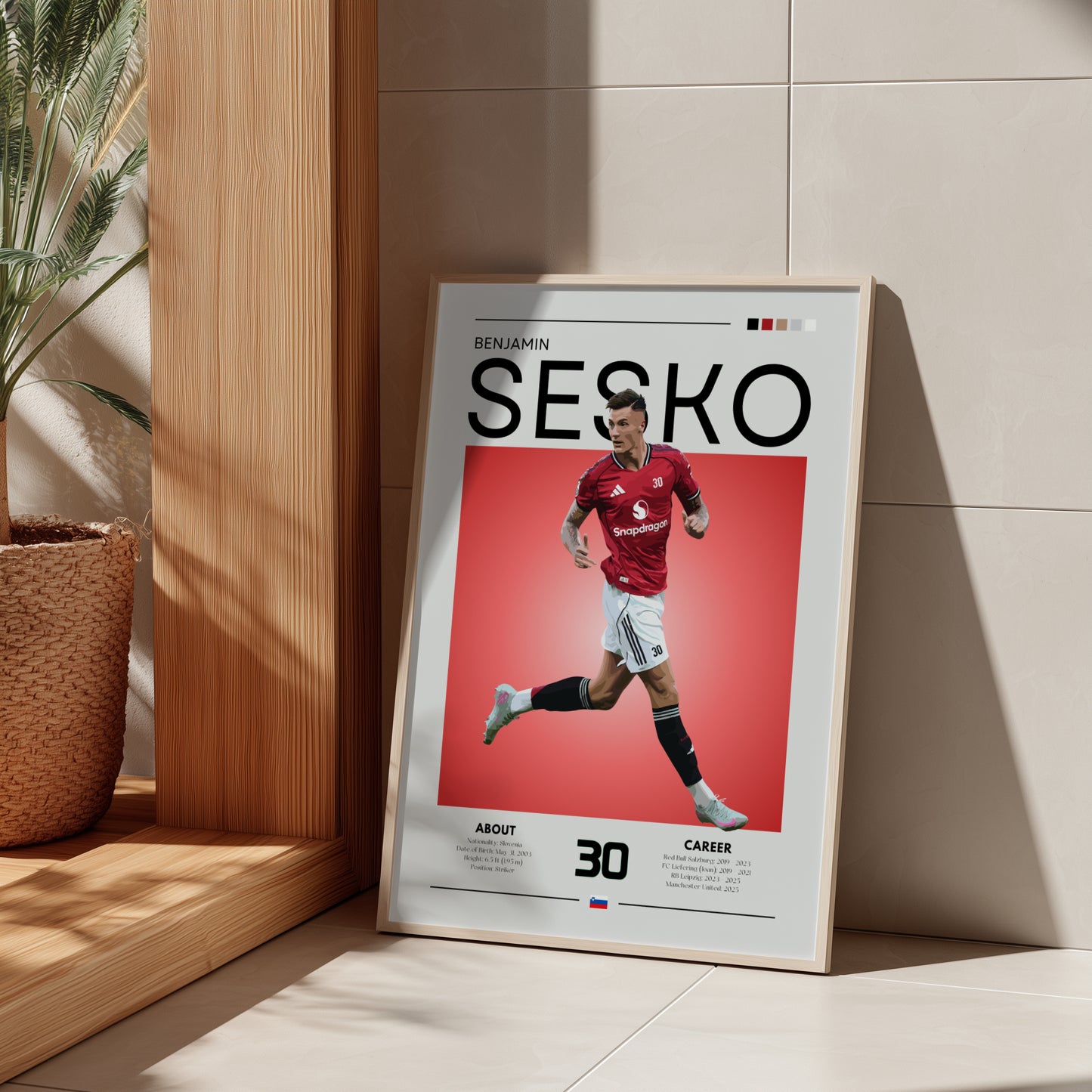 Framed poster of a soccer player with 'SESKO' branding on a light wooden shelf.