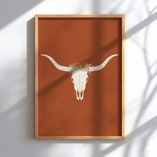 Poster featuring a white bull skull with a wildflower crown on terracotta background