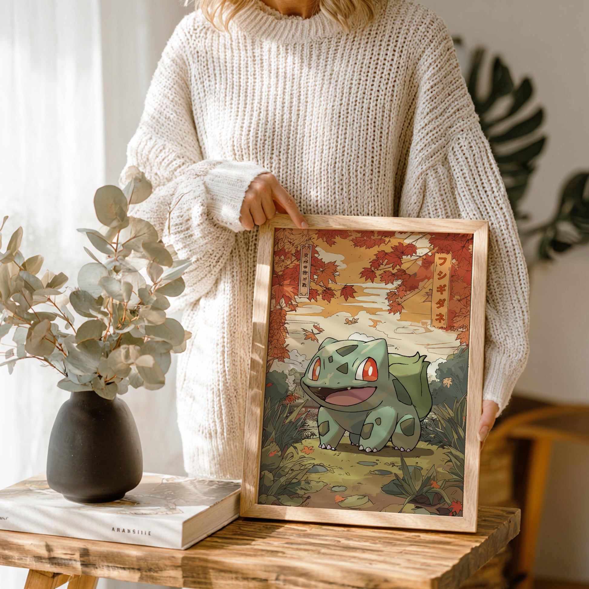 Person holding a framed illustration of Bulbasaur Pokemon in a natural setting.