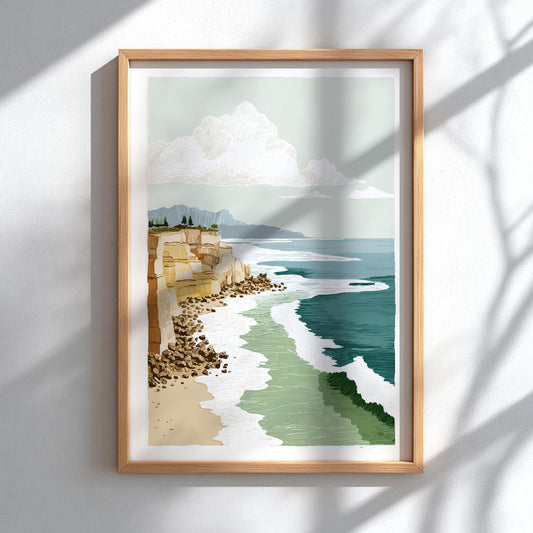 Framed artwork of a coastal landscape with cliffs and ocean on a white wall.