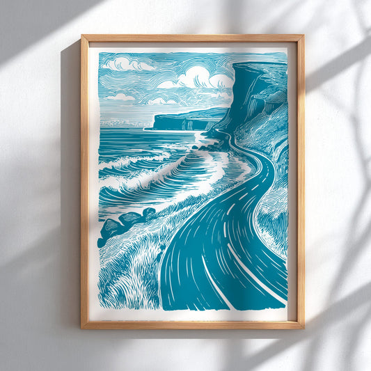 Framed artwork of a coastal scene with waves and cliffs on a white wall.