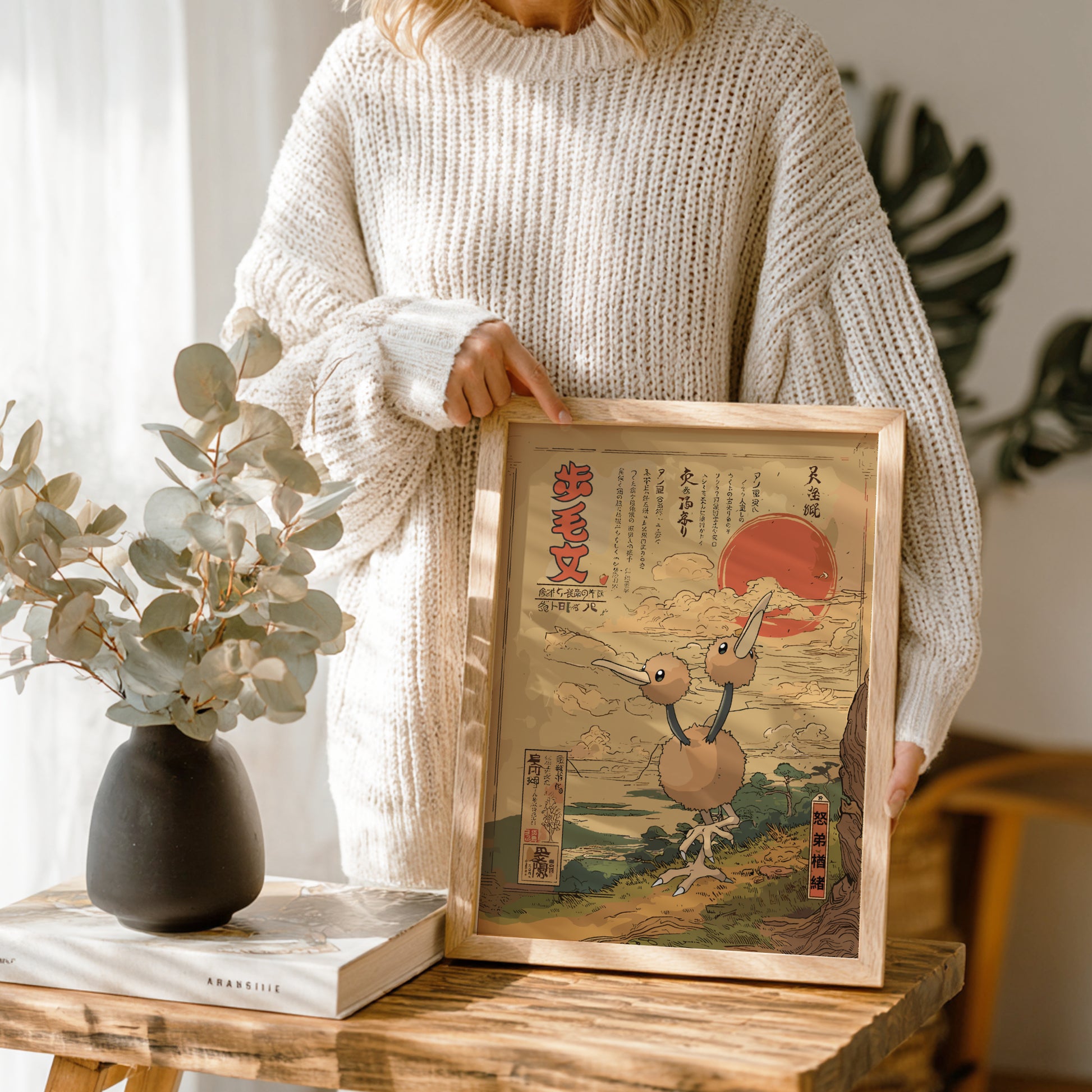 Person holding a framed artwork of Doduo Pokemon and cherry blossom tree in a wooden frame.