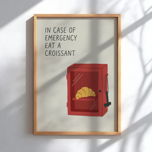 Poster featuring a red emergency box containing a golden croissant on a cream background.
