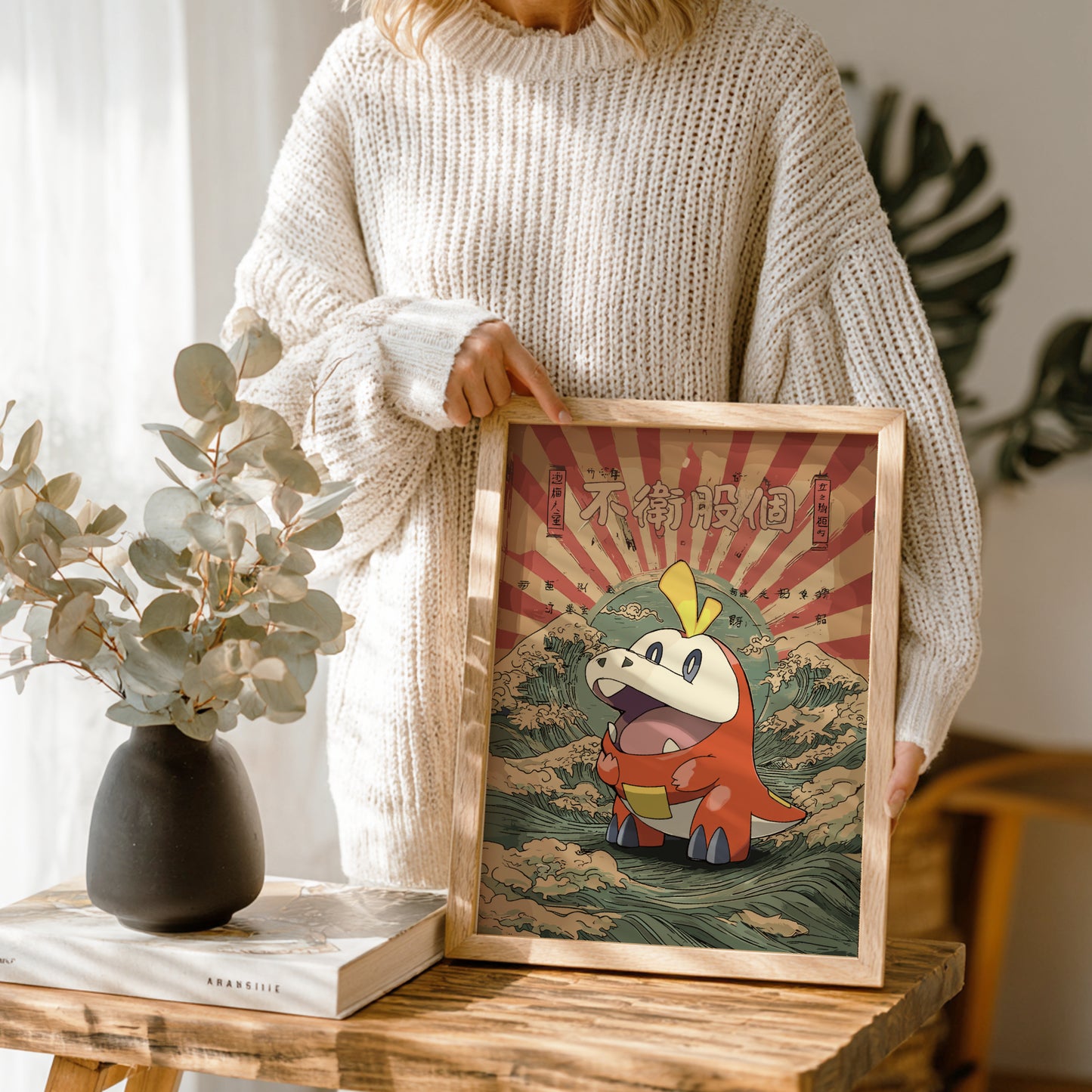 Person holding a framed illustration of Fuecoco Pokemon character with a decorative background