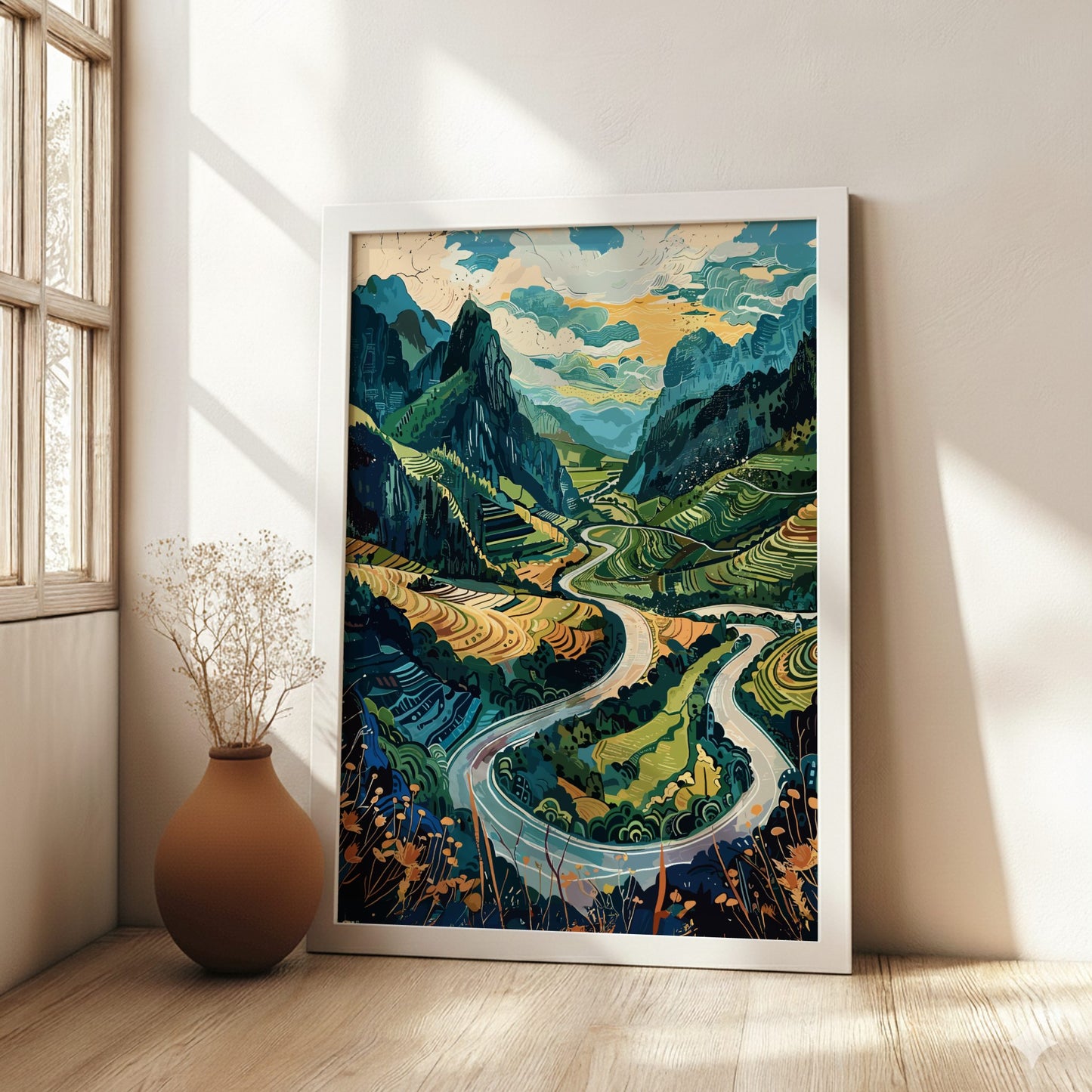 Framed artwork of a mountain landscape with a river in a room with a vase on the floor.