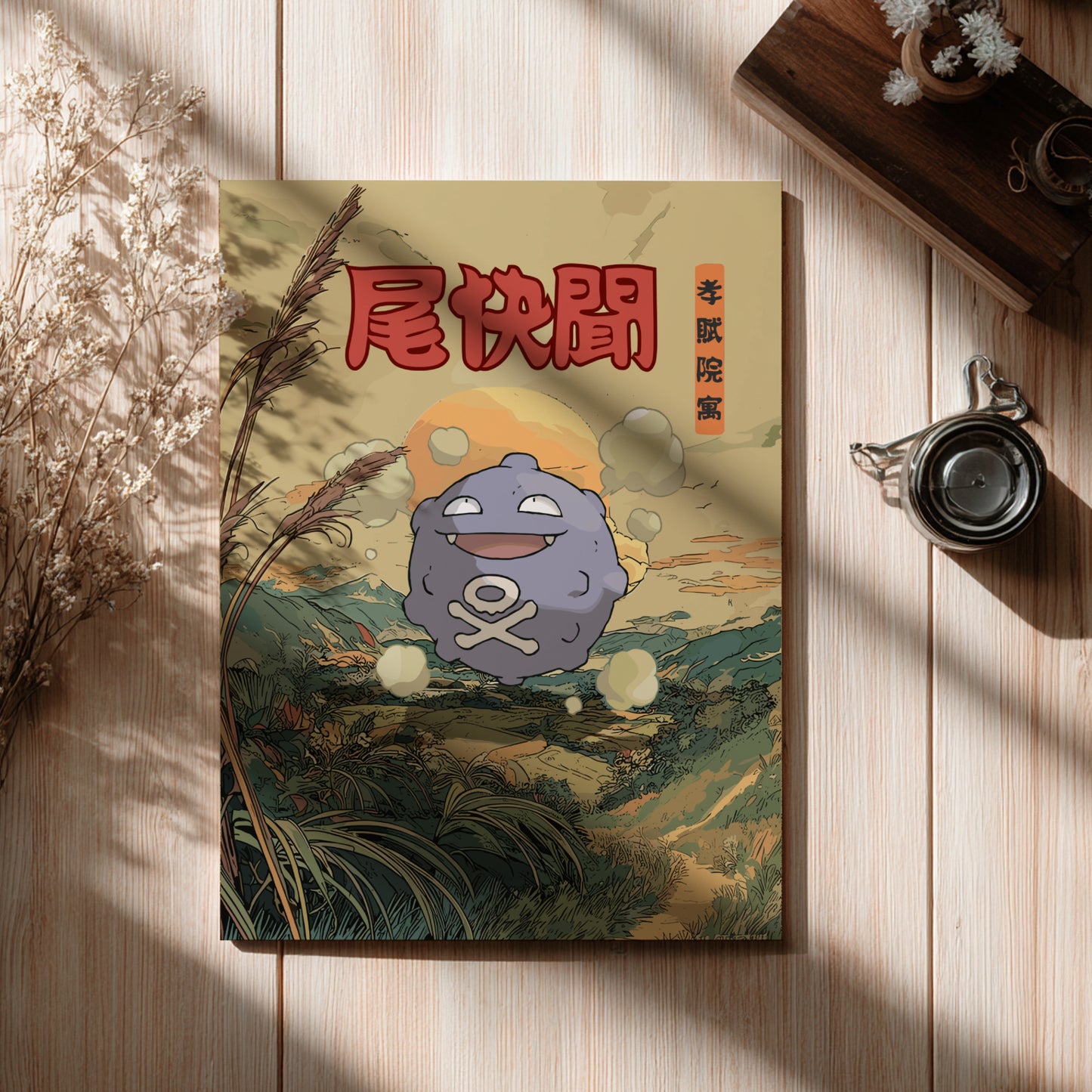 Poster with Koffing Pokemon character and Japanese text on a wooden surface with dried plants and a teacup.