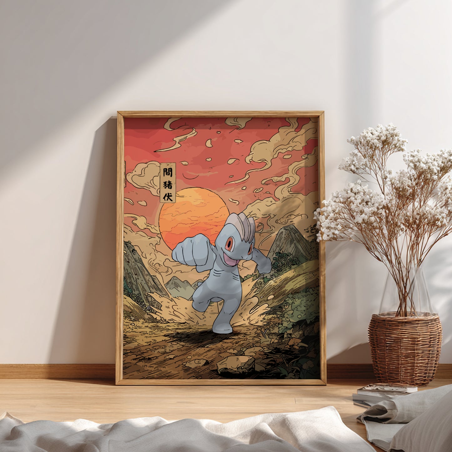 Framed artwork of Machop Pokemon in a mountainous landscape with a warm sunset, placed on a wooden floor.