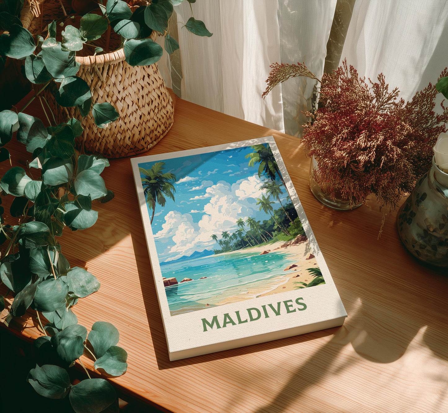 Canvas 'Maldives' with a beach illustration on a wooden table with plants.
