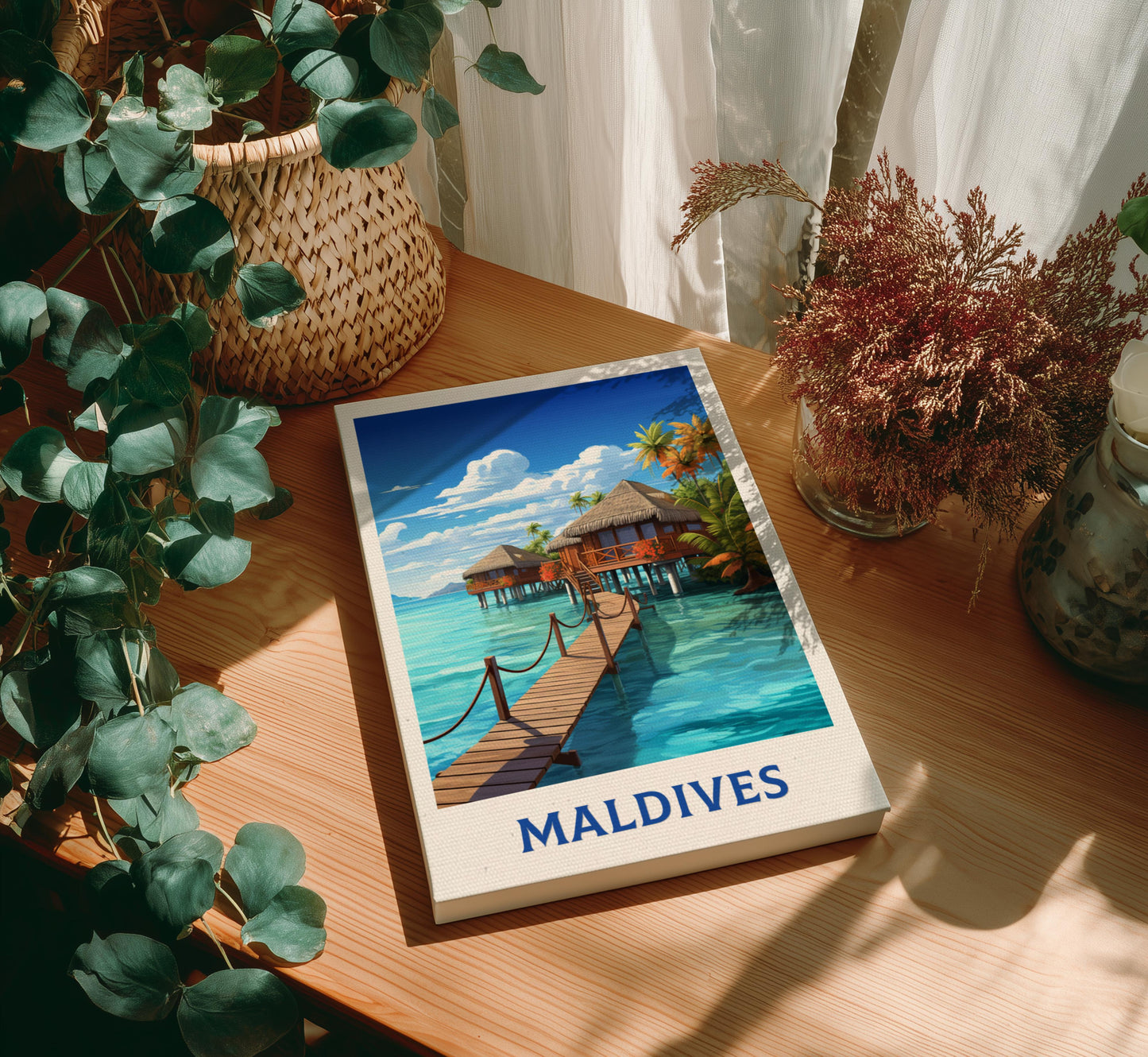 Canvas of 'Maldives' with a scenic illustration on a wooden table with plants.