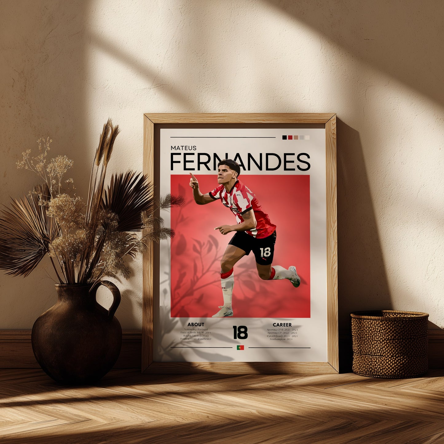 Framed poster of a soccer player with 'Mateus Fernandes' on a red background, placed on a wooden surface with decorative elements.