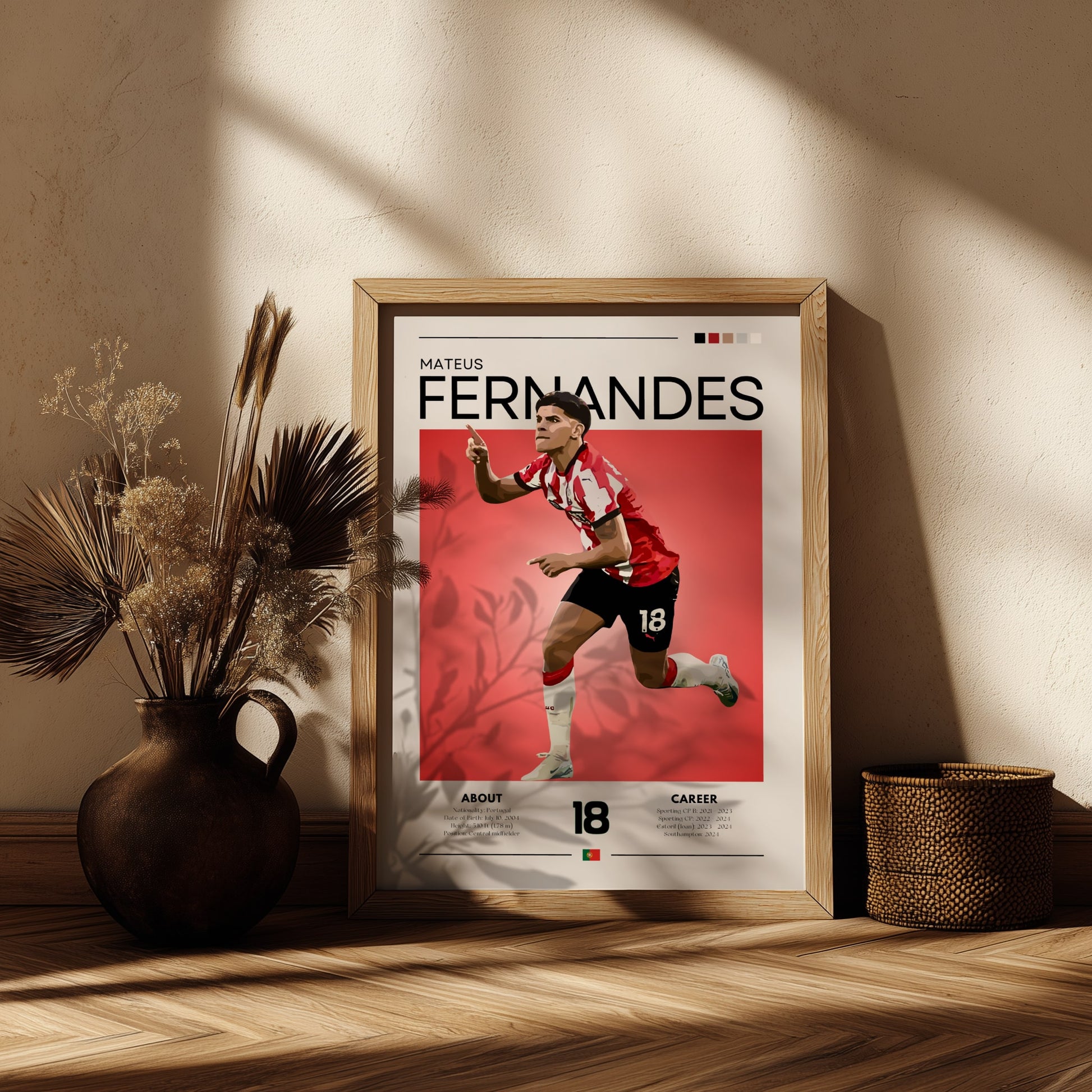 Framed poster of a soccer player with 'Mateus Fernandes' on a red background, placed on a wooden surface with decorative elements.