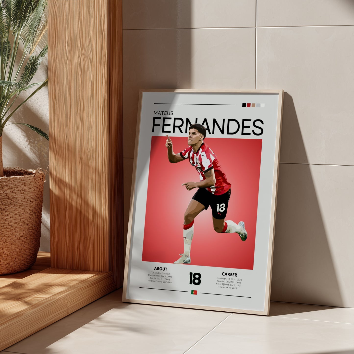 Framed poster of a soccer player with 'Fernandes' on a red background, leaning against a wall.
