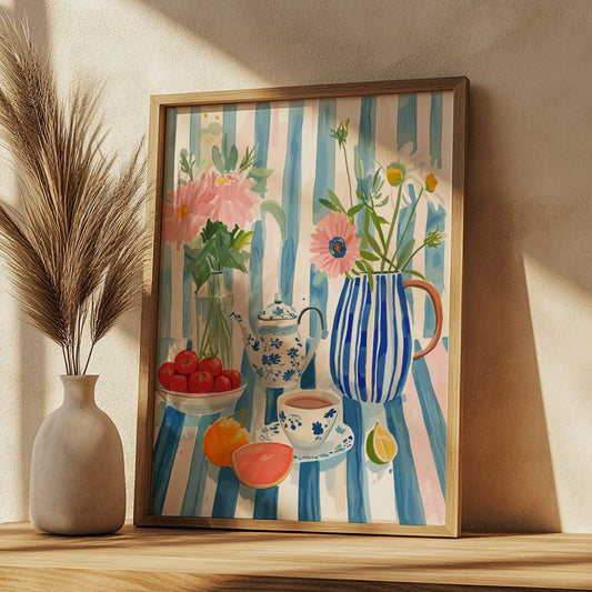Framed artwork of a still life scene with flowers, fruits, and a teapot on a striped background.