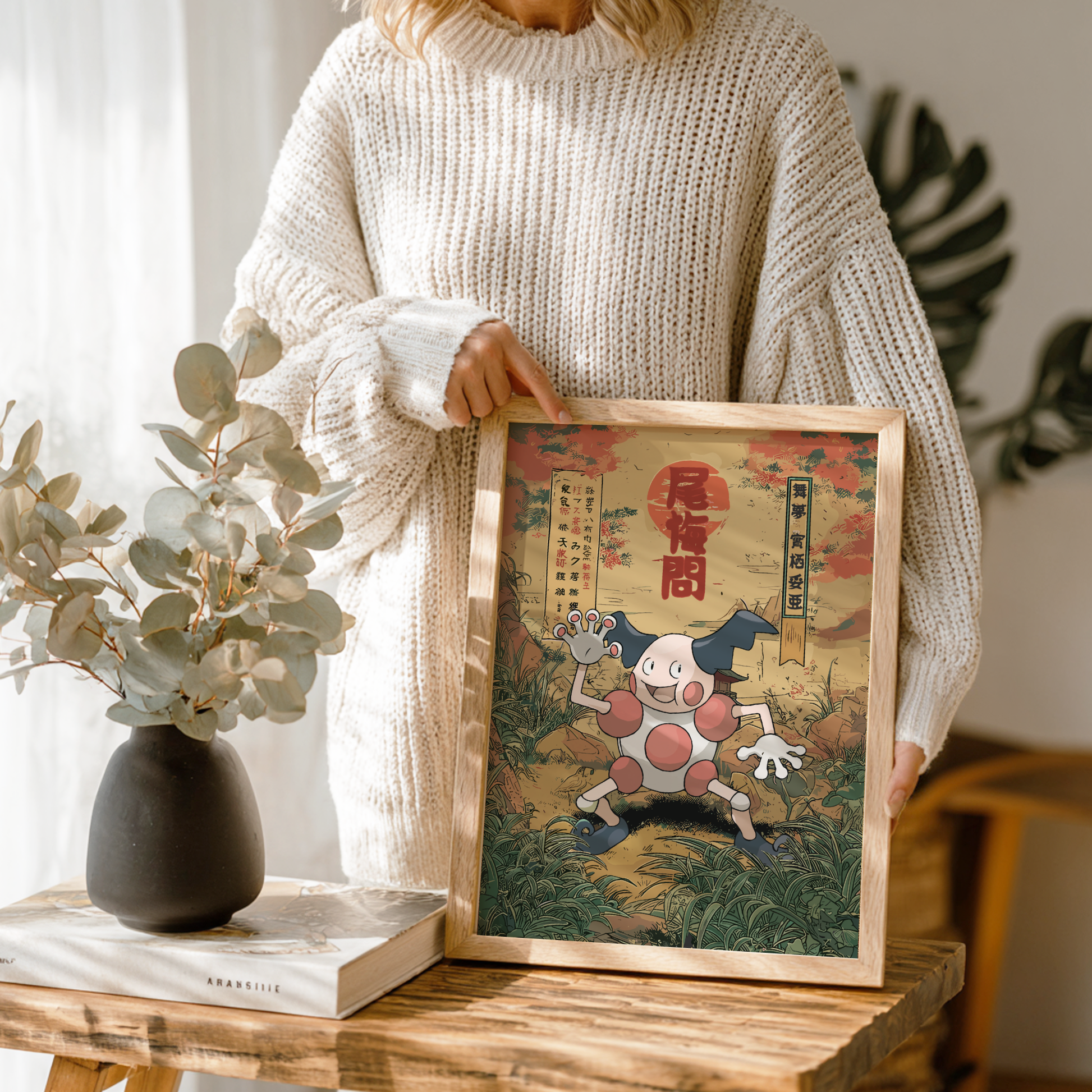 Person holding a framed artwork of Mr. Mime Pokemon in a room with decor elements.
