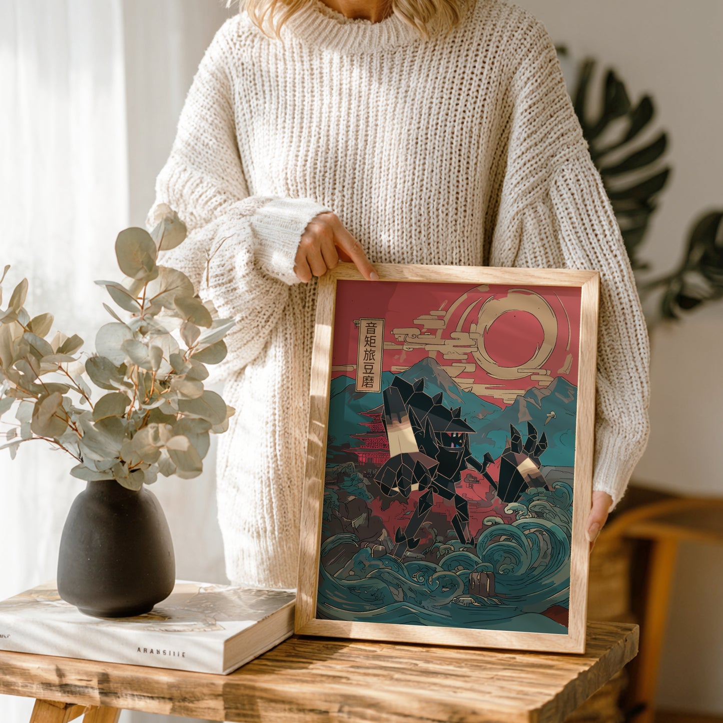 Person holding a framed artwork with a stylized design Necrozma Pokemon, set against a mountain and wave background.
