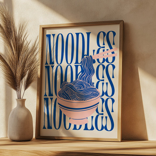 Framed artwork with 'Noodles' text and illustration on a wooden shelf.