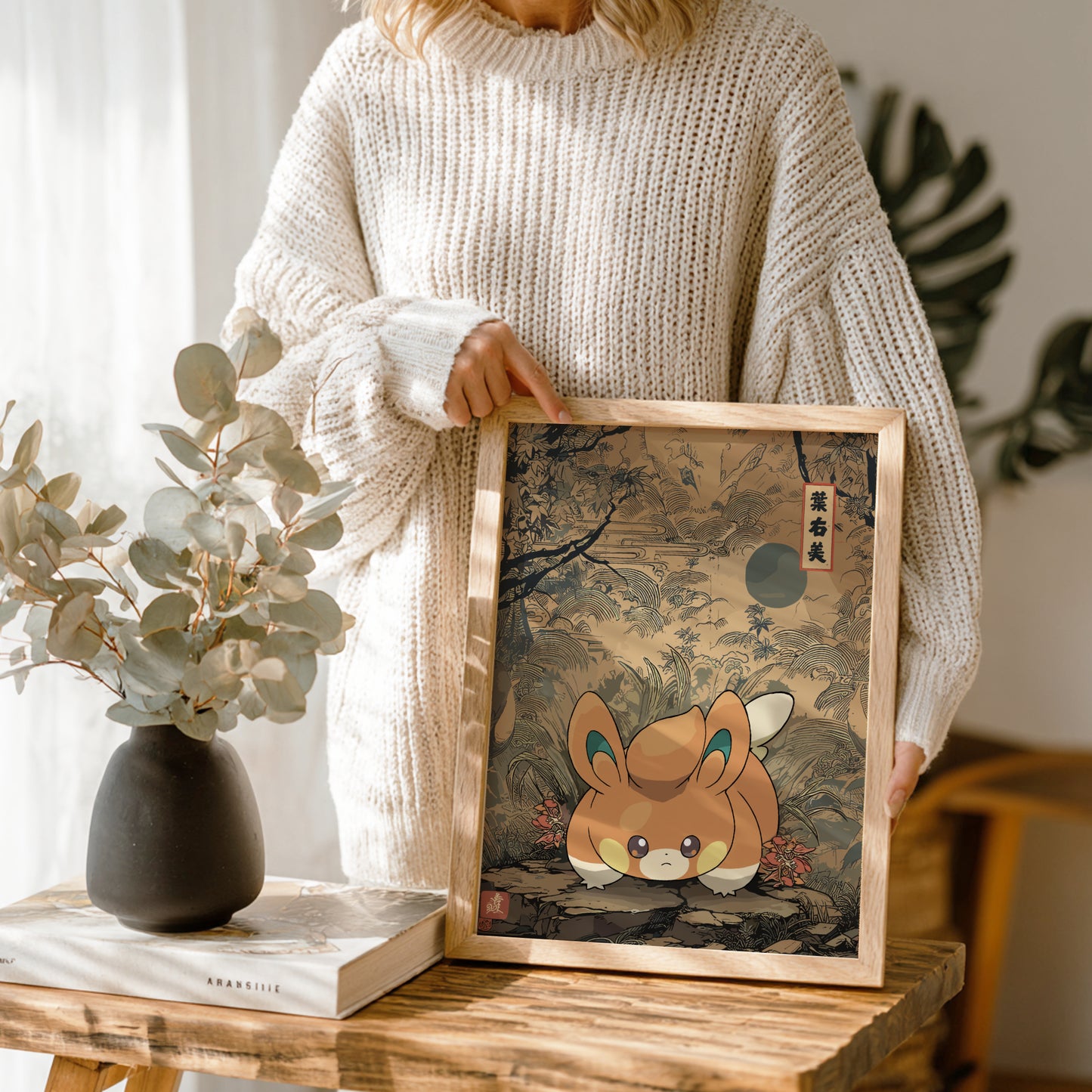 Person holding a framed artwork of Pawmi Pokemon in a natural setting