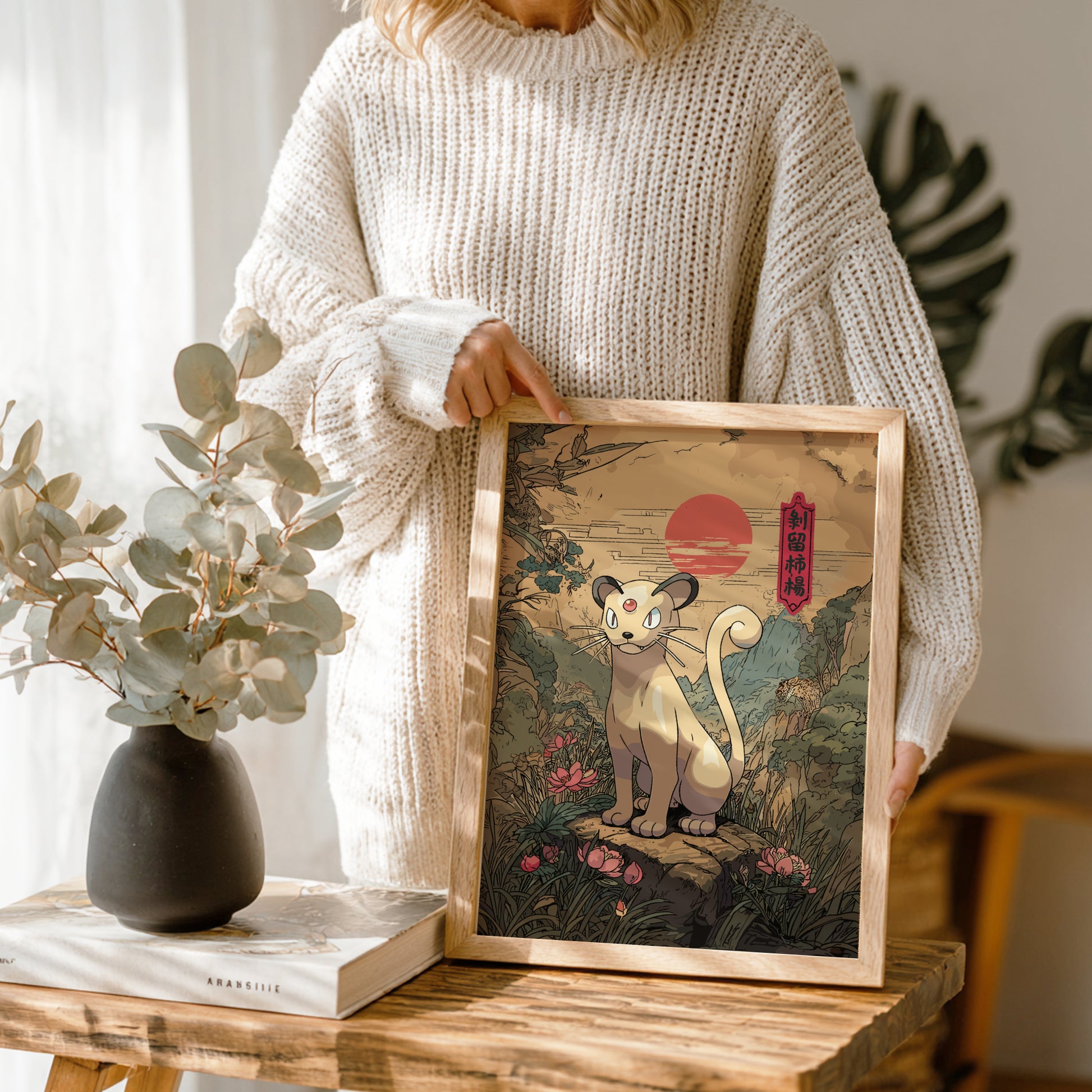 Person holding a framed artwork of Persian Pokemon in a natural setting