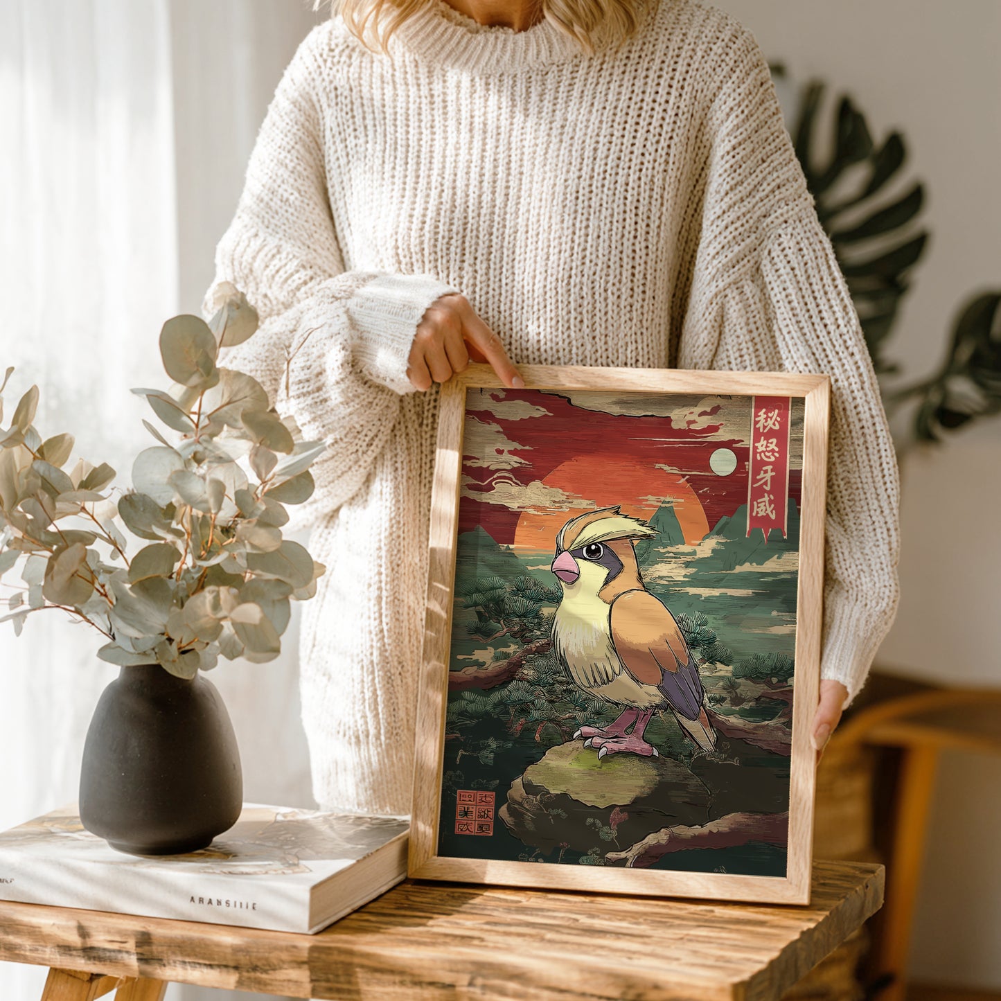 Person holding a framed artwork of Pidgey Pokemon in a natural setting