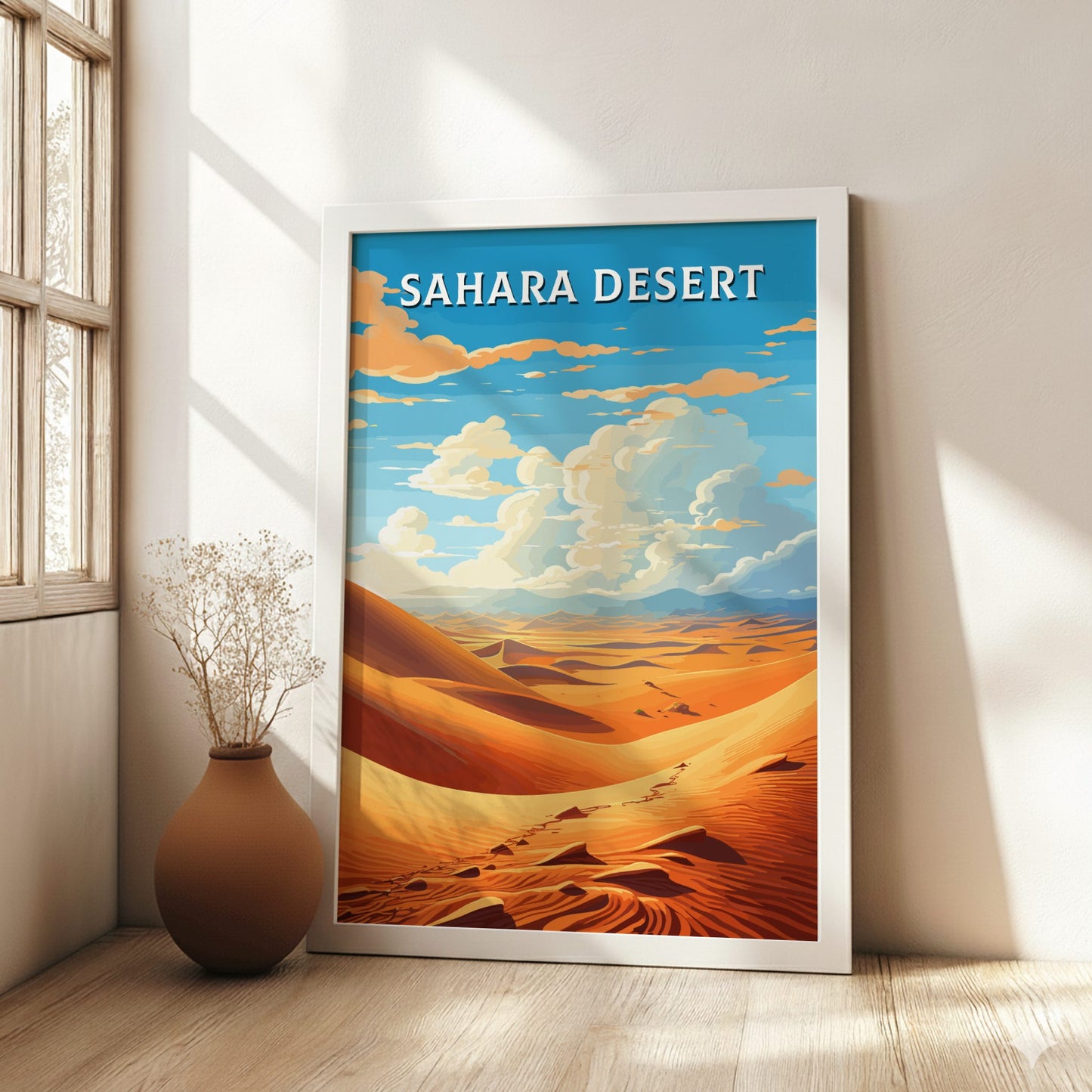 Framed artwork of the Sahara Desert in a room with a vase on a wooden floor.