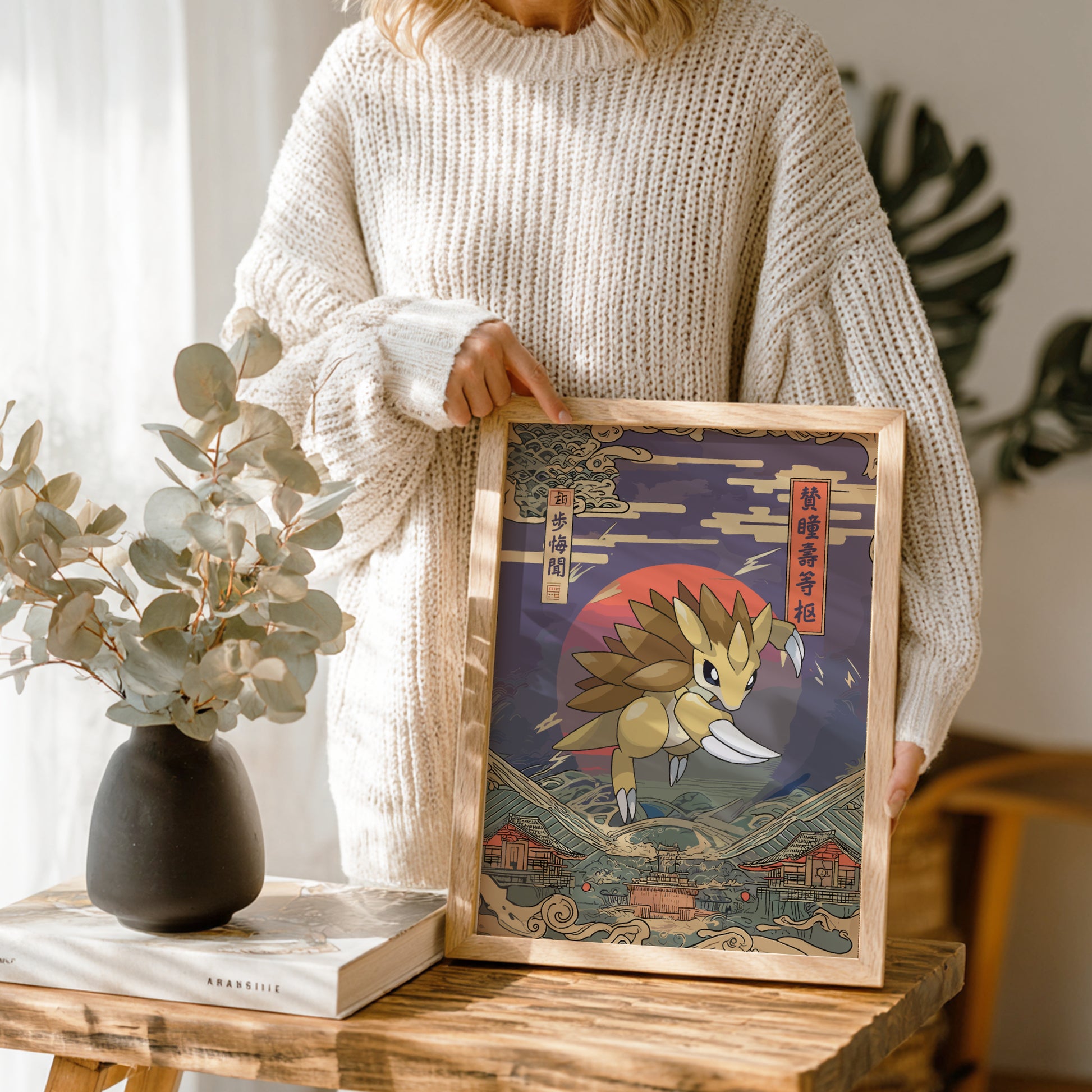 Person holding a framed artwork of Sandslash Pokemon with a mountainous background