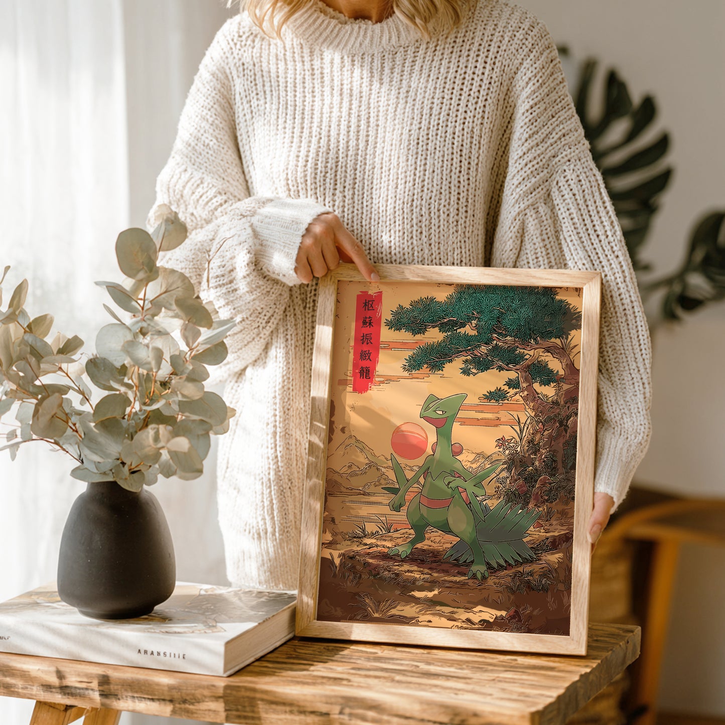 Person holding a framed artwork of Sceptile Pokemon in a natural setting