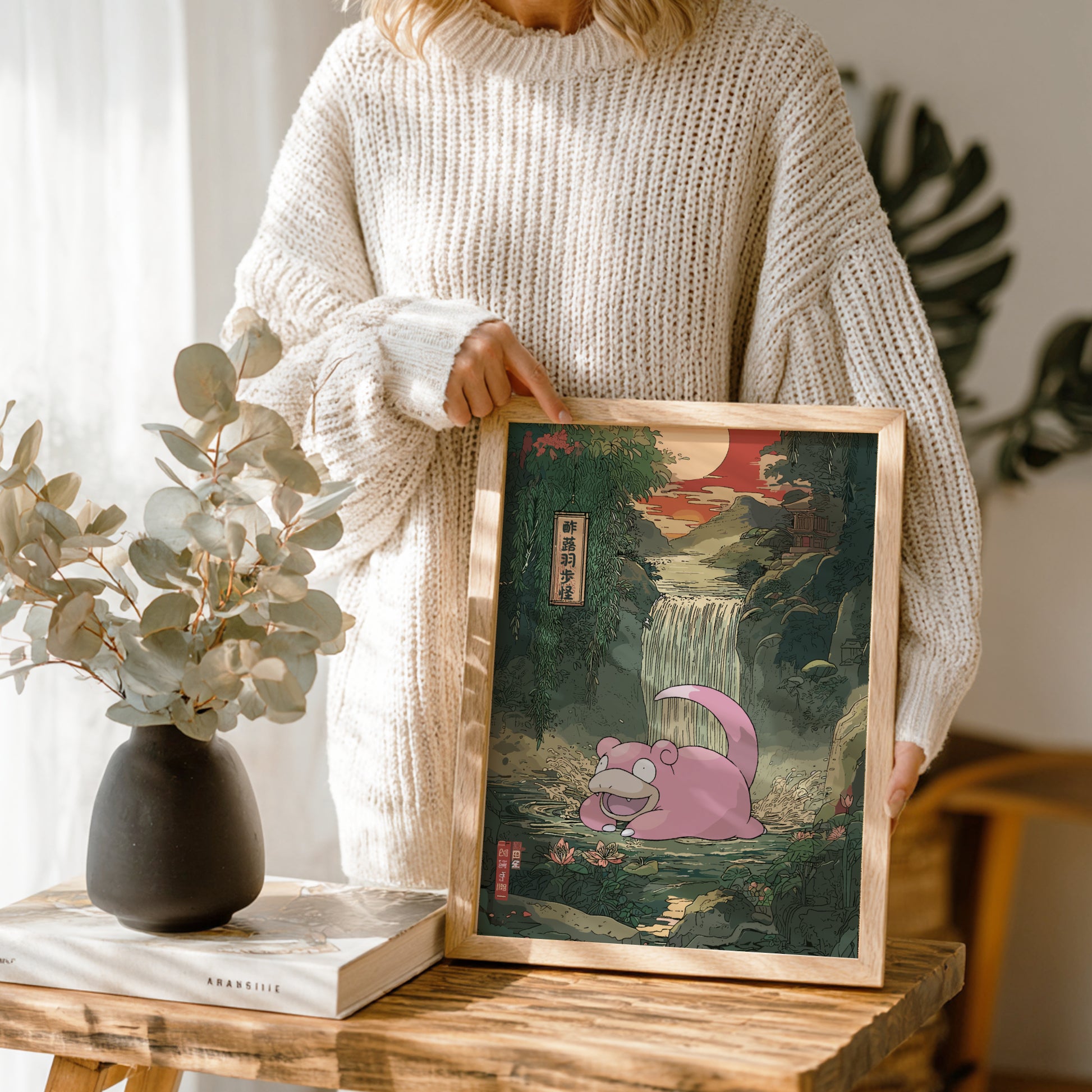 Person holding a framed artwork of Slowpoke Pokemon in a natural setting