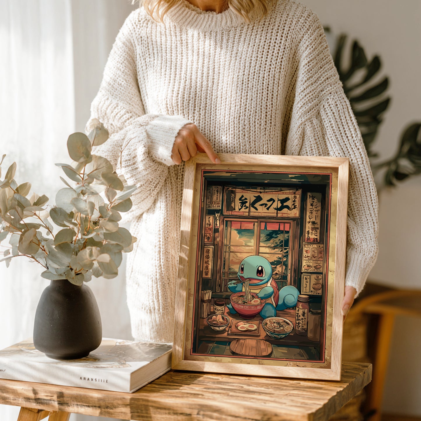 Person holding a framed artwork of Squirtle character in a restaurant setting.