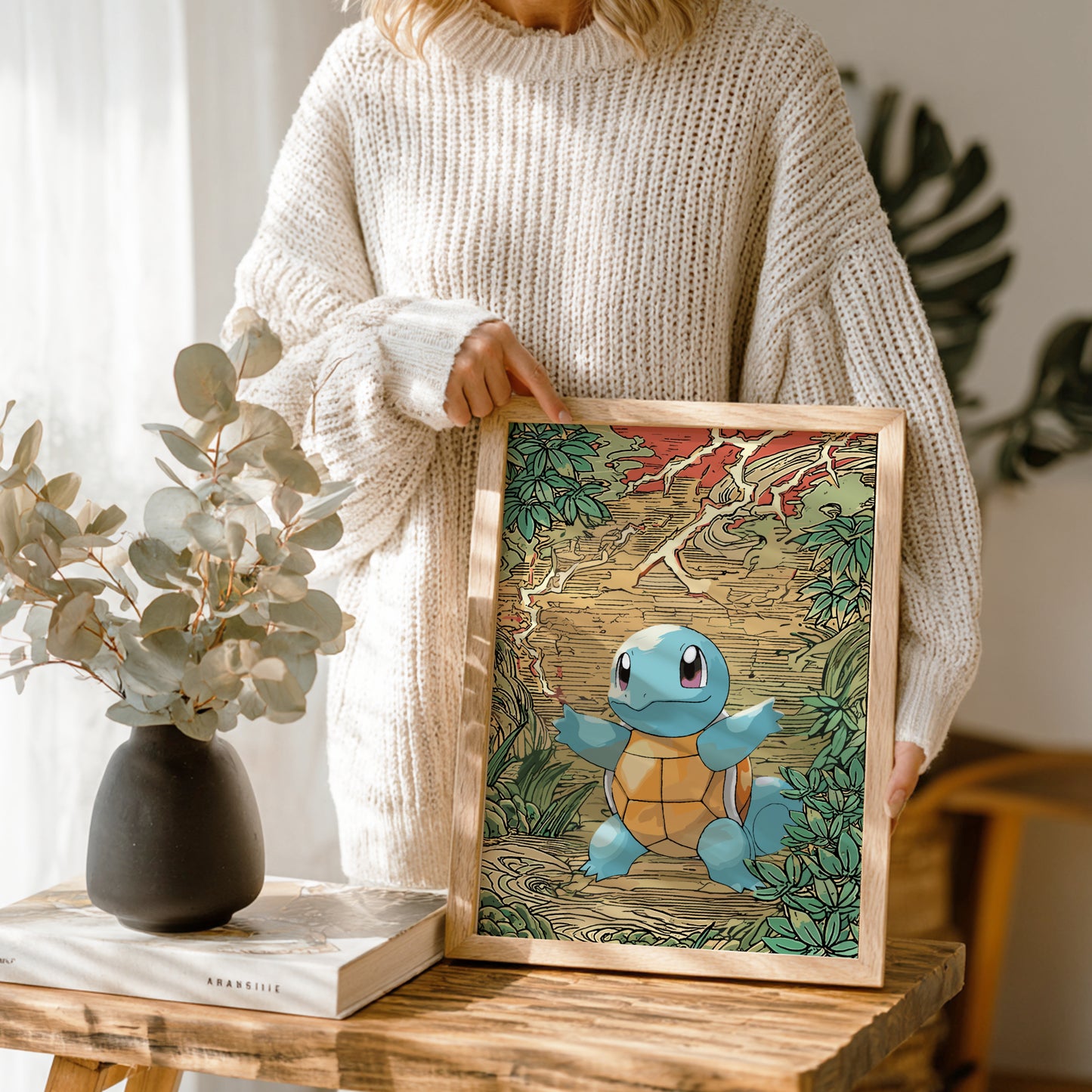 Person holding a framed illustration of Squirtle Pokemon in a natural setting