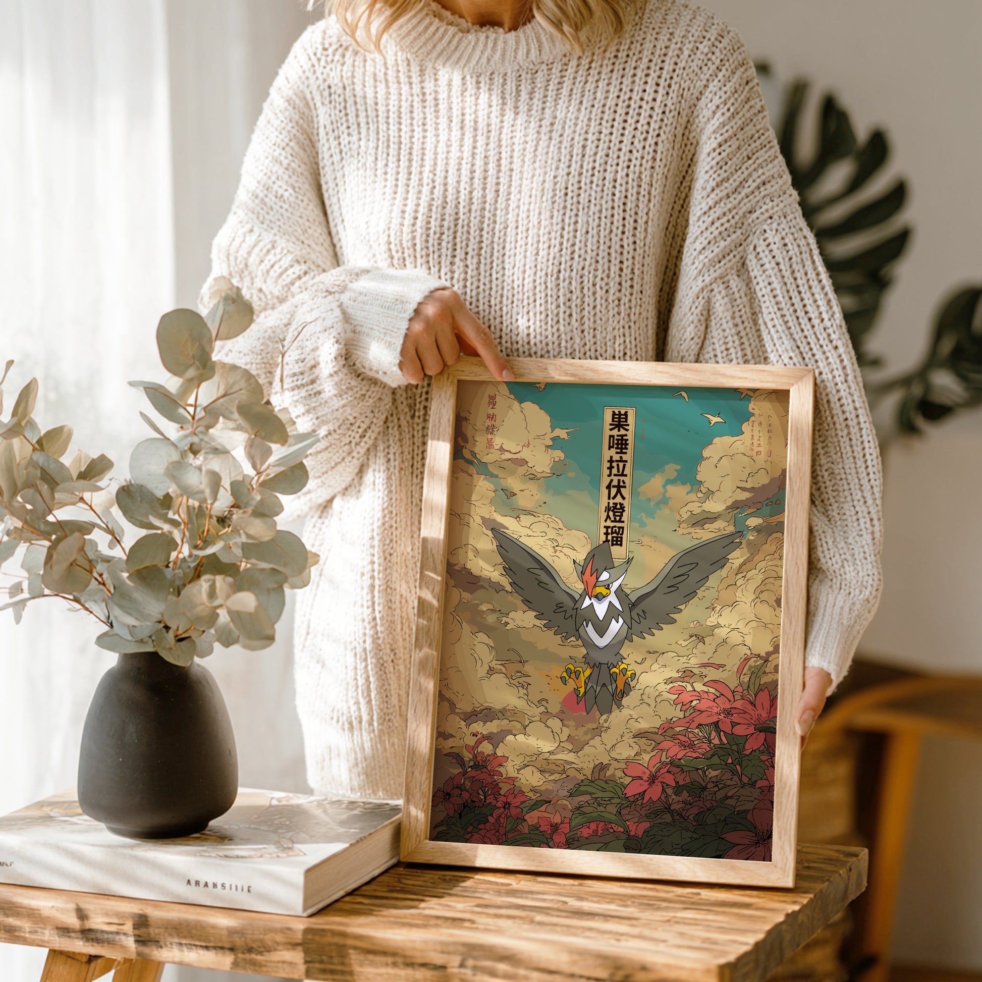 Person holding a framed artwork of Staraptor Pokemon in a natural setting