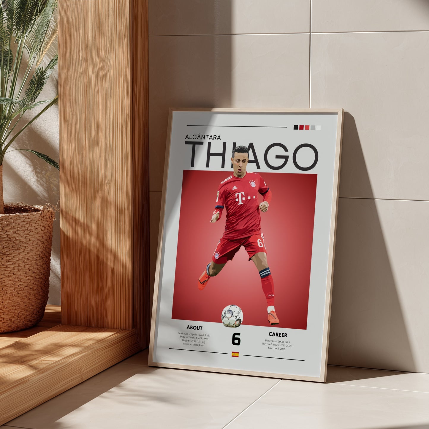 Framed poster of a soccer player in a red uniform on a light wooden shelf.