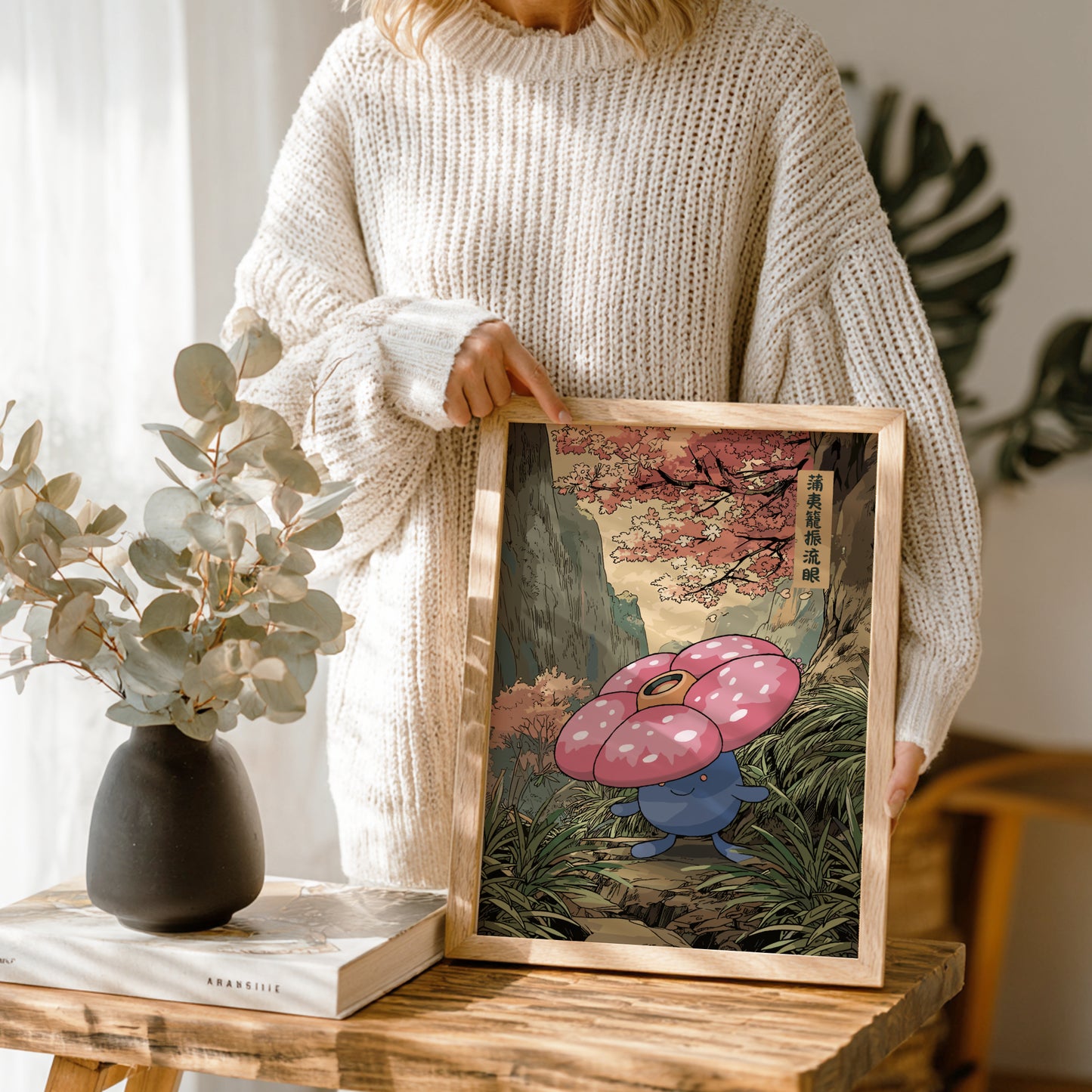 Person holding a framed artwork of Vileplume Pokemon in a natural setting.