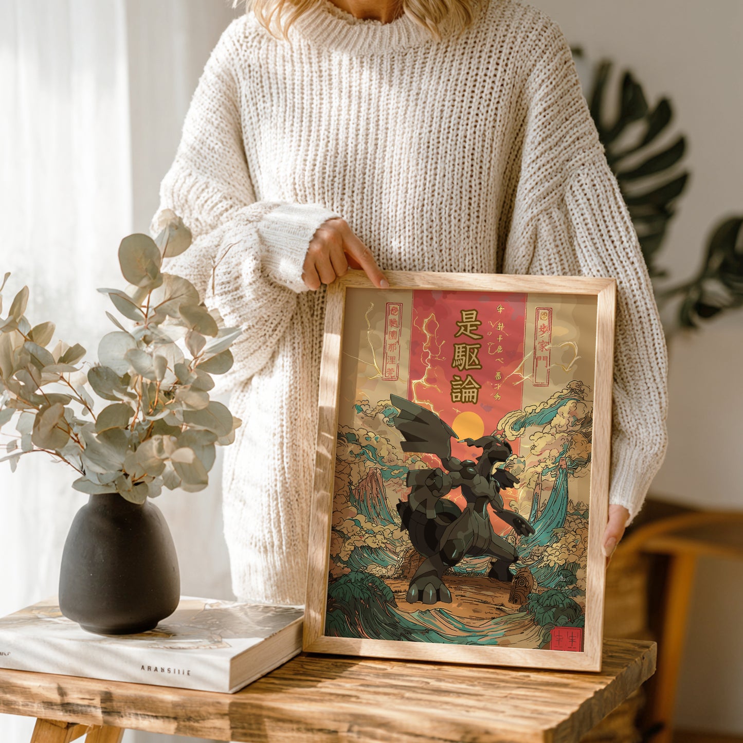 Person holding a framed artwork with a Zekrom Pokemon design in a home setting