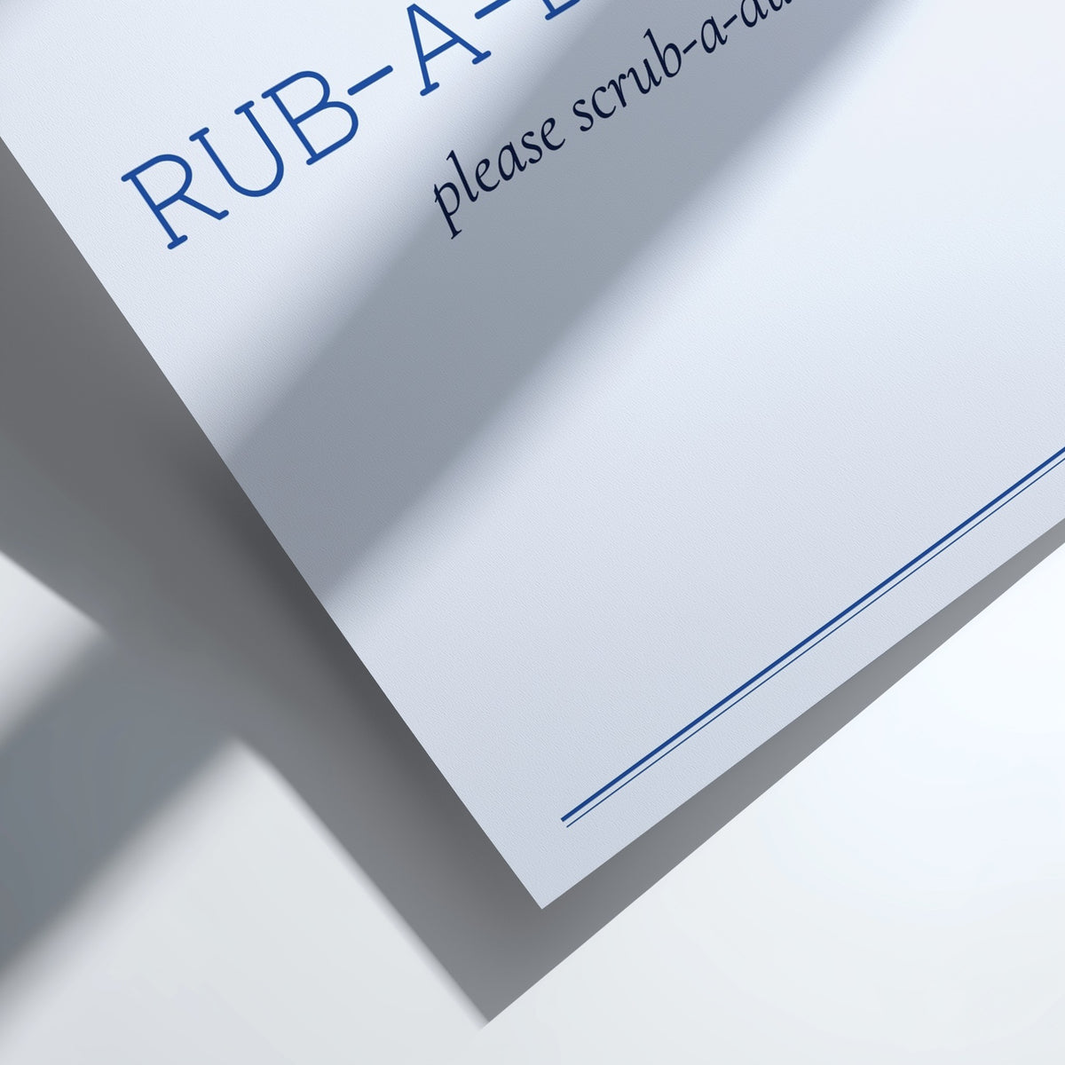 A close-up of a white paper sign or card with blue text reading 'RUB-A-.