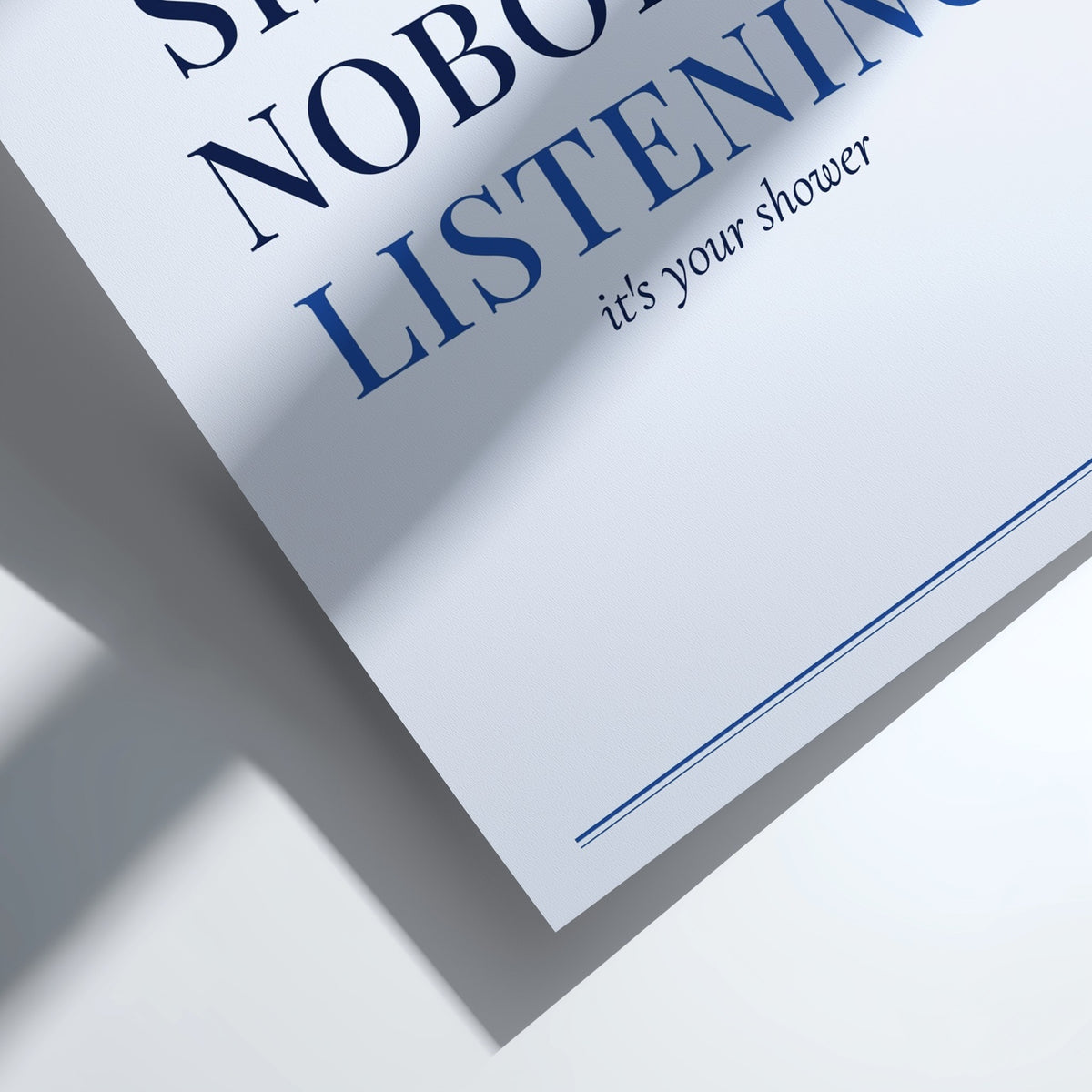 A close-up of a printed card or sign with partial text reading 'LISTENING' and 'it's your shower' on a white background, cast with strong diagonal shadows.