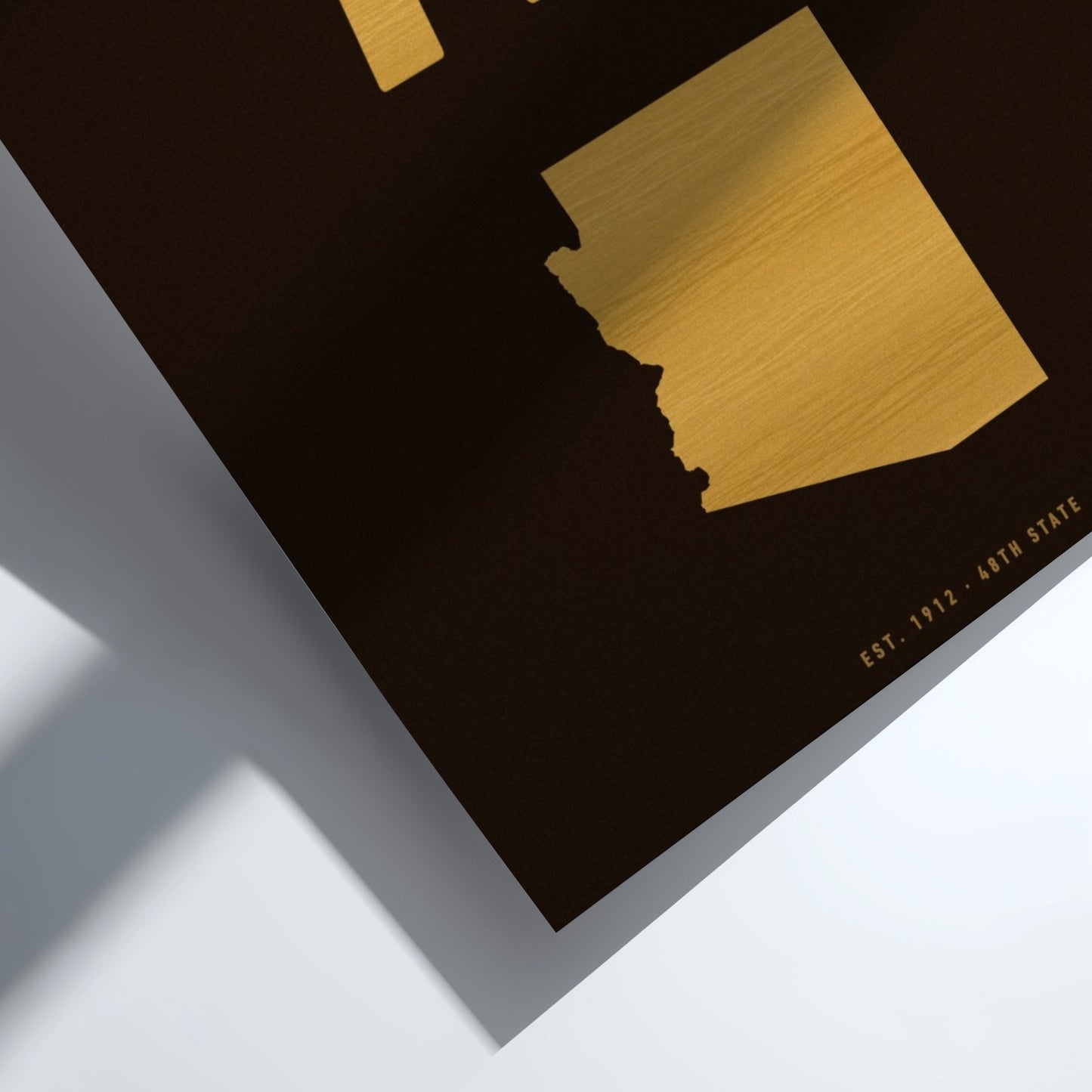 Gold map of Arizona on a black background