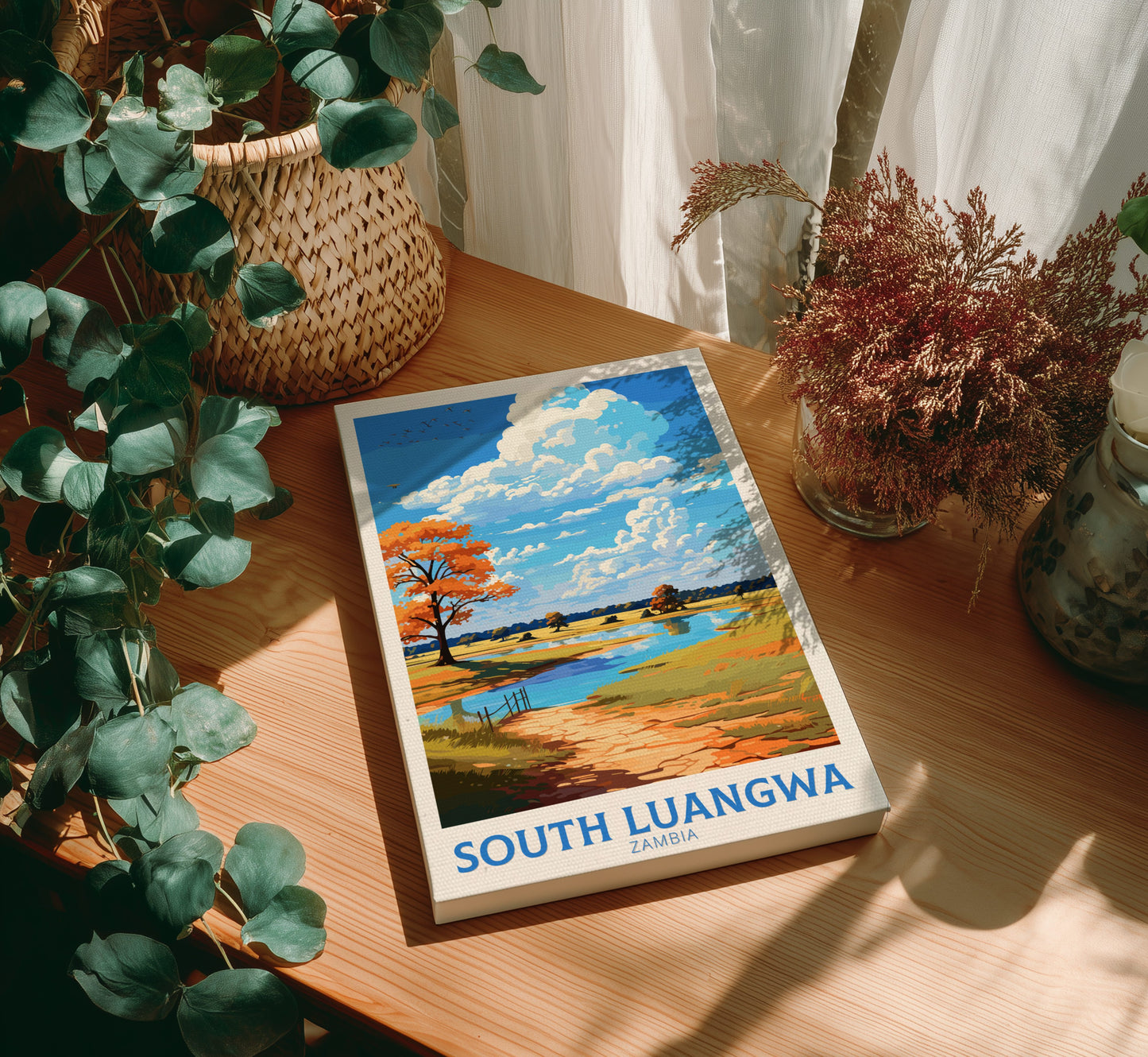 Book titled 'South Luangwa' on a wooden surface with plants around
