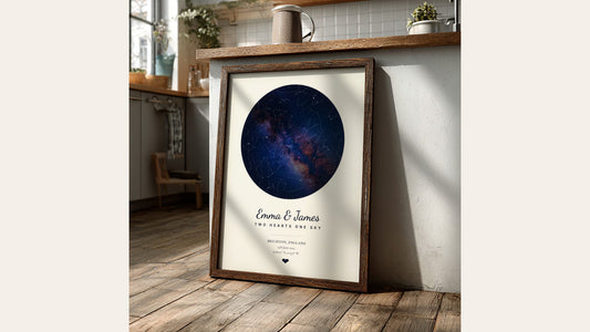 Navy star map poster with the Milky Way in a dark wood frame, leaning against a sunny kitchen counter