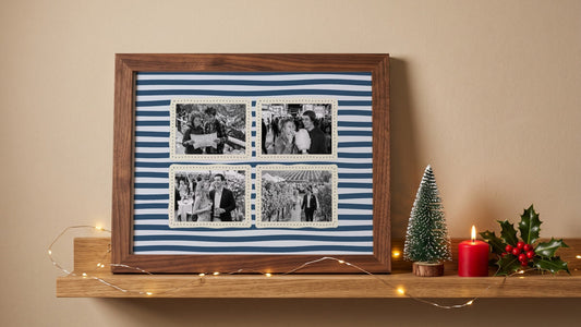 Four-photo couples print on navy stripes in a walnut frame on a shelf with fairy lights, a mini Christmas tree, a candle and holly