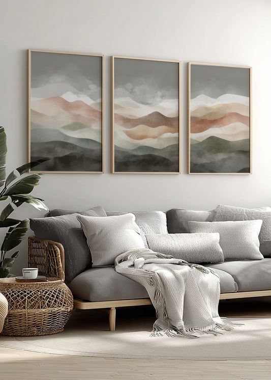 Gray sofa with decorative pillows and a blanket in a living room with abstract wall art.