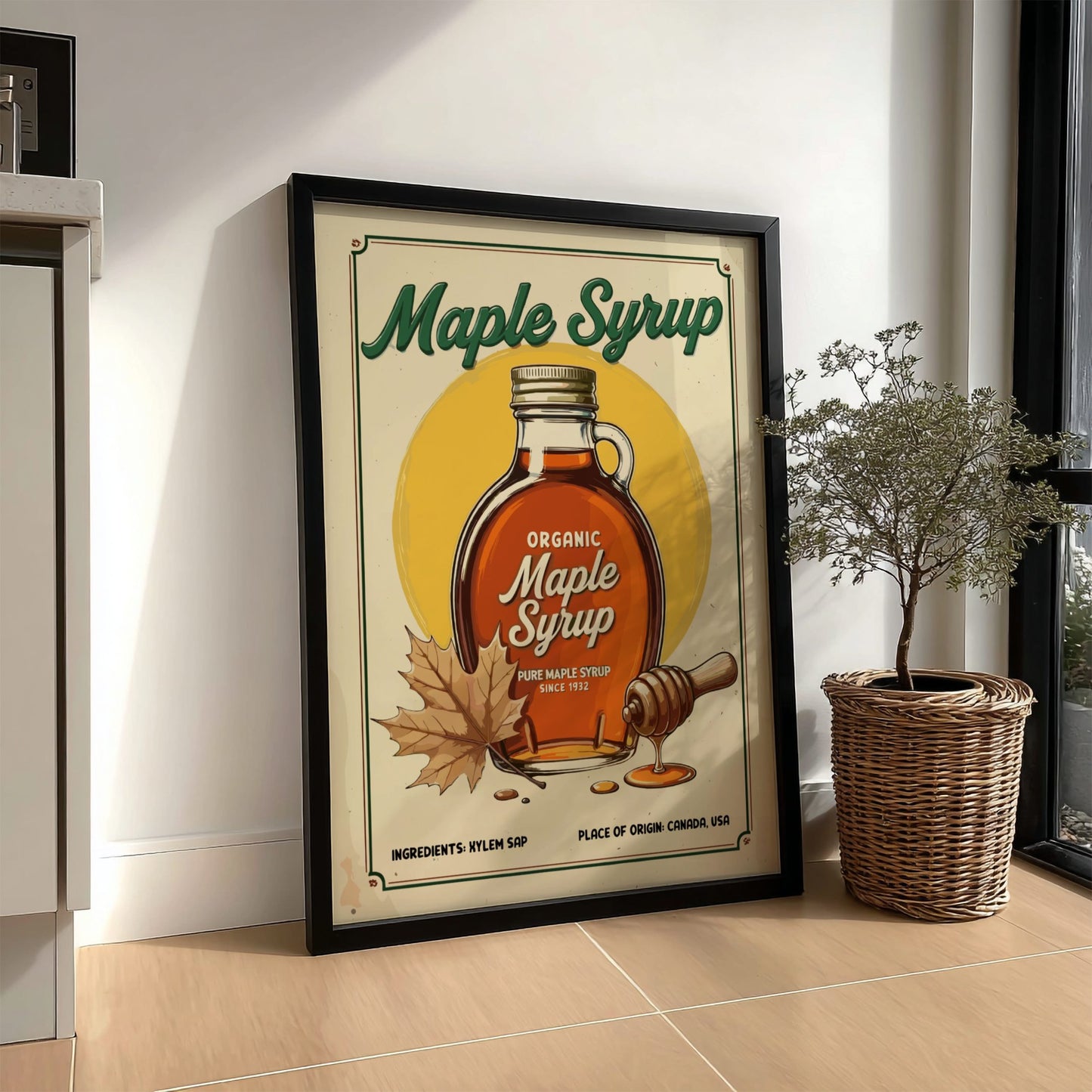 Framed poster of organic maple syrup with a bottle and leaf design, placed on a floor.