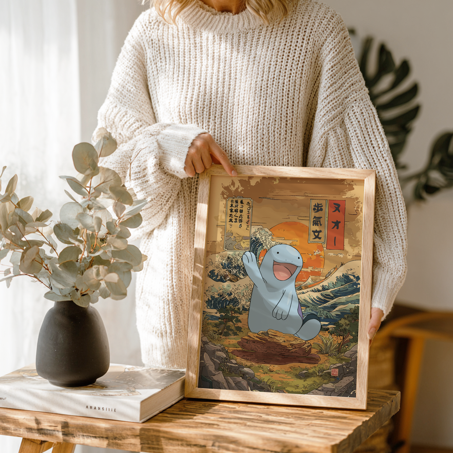 Person holding a framed artwork of Quagsire Pokemon in a scenic setting