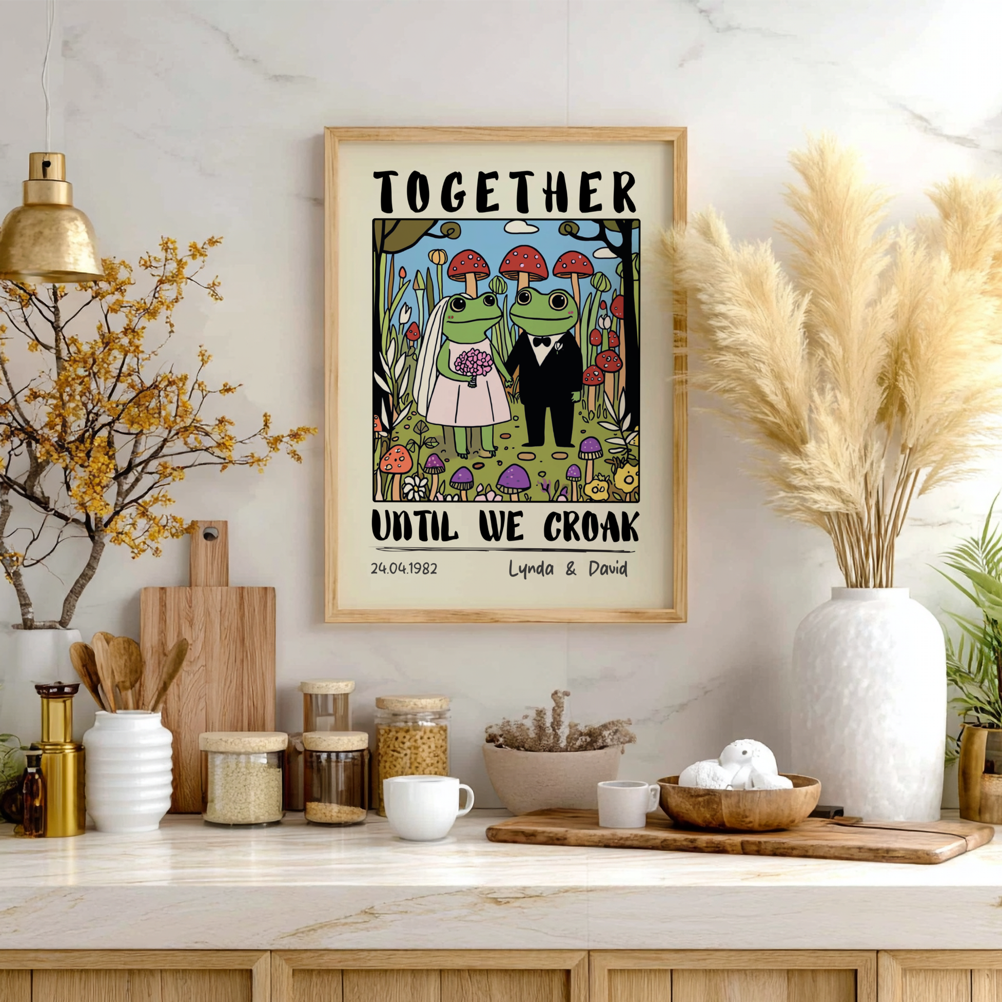 Framed artwork with 'Together Until We Croak' text on a kitchen wall with decor items.