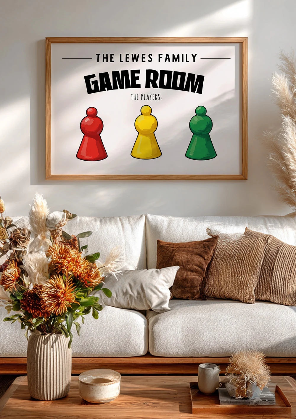 Framed artwork with 'The Lewes Family Game Room' text and colorful game pieces on a wall above a sofa.