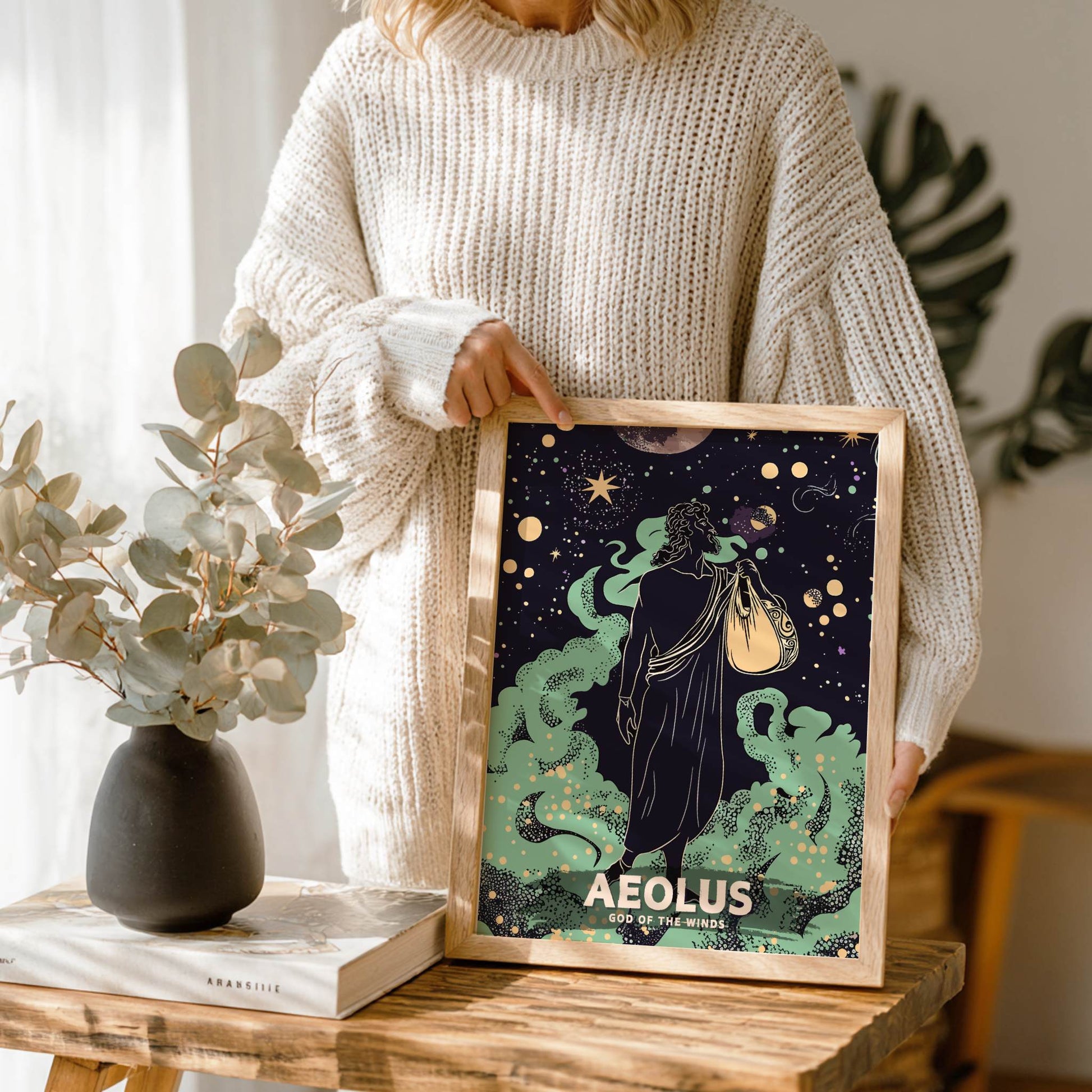 Person holding a framed print of 'Aeolus, God of the Winds' in a home setting.