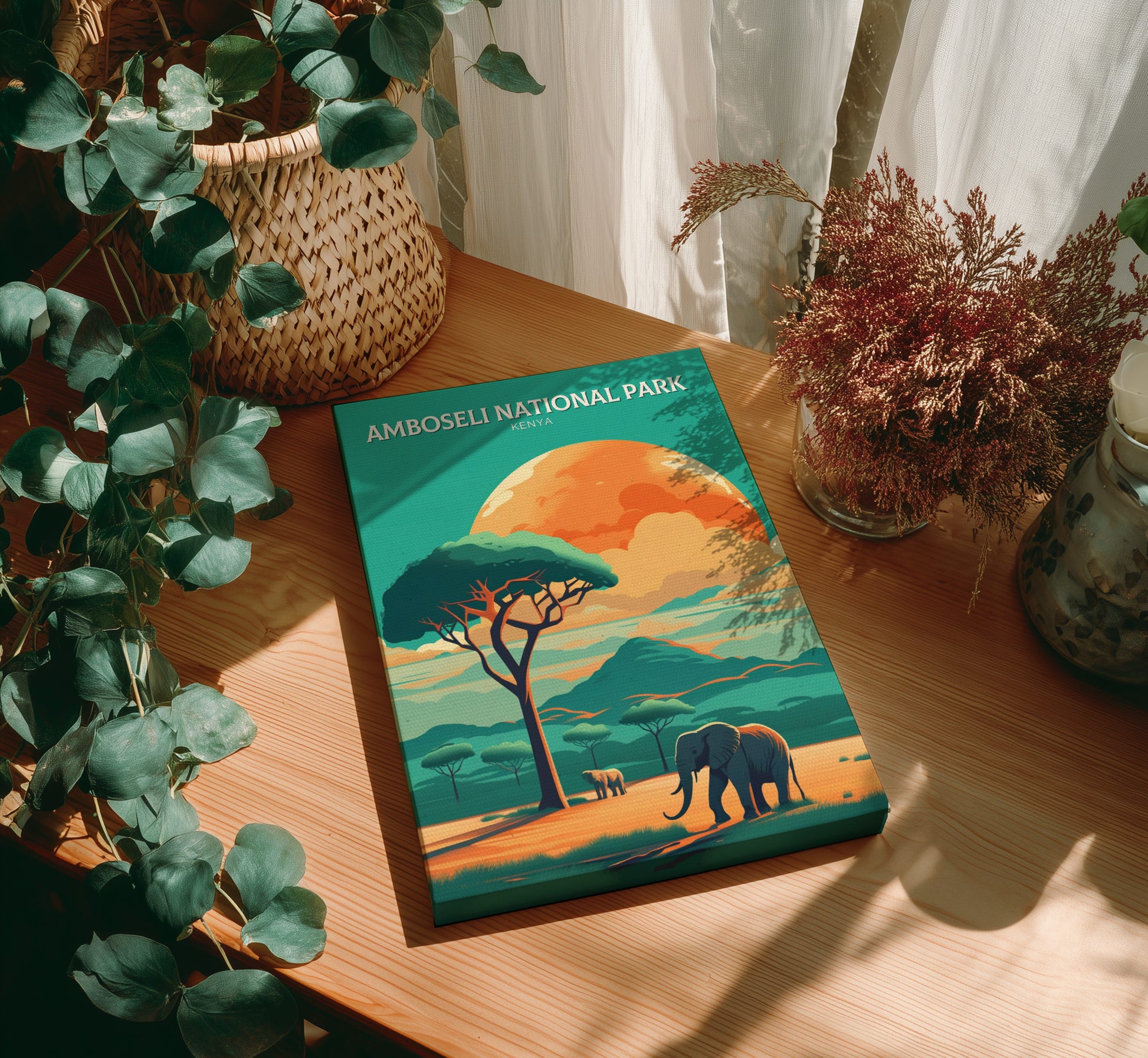 Book titled 'Amboseli National Park' on a wooden table with plants.
