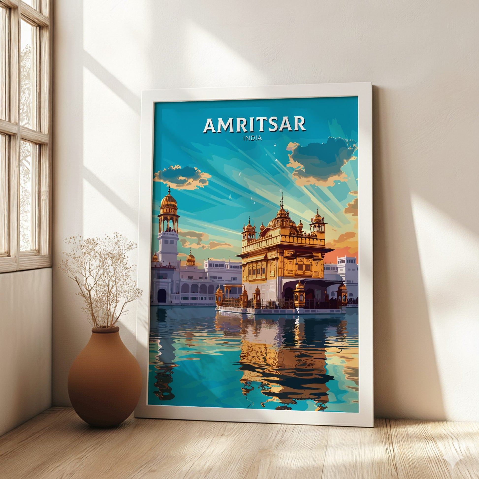 Framed poster of Amritsar, India with a temple reflection in water, in a room with a vase and window.