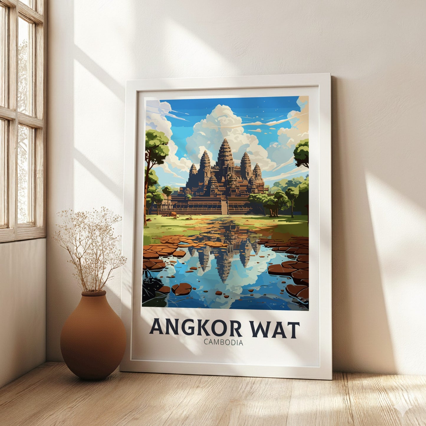 Framed poster of Angkor Wat in a bright room with a vase on the floor.